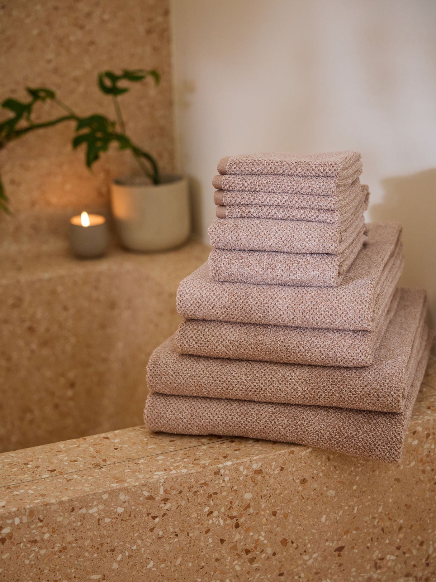 The Complete Nantucket Bath Bundle is pictured sitting on the edge of a stone bathtub. 