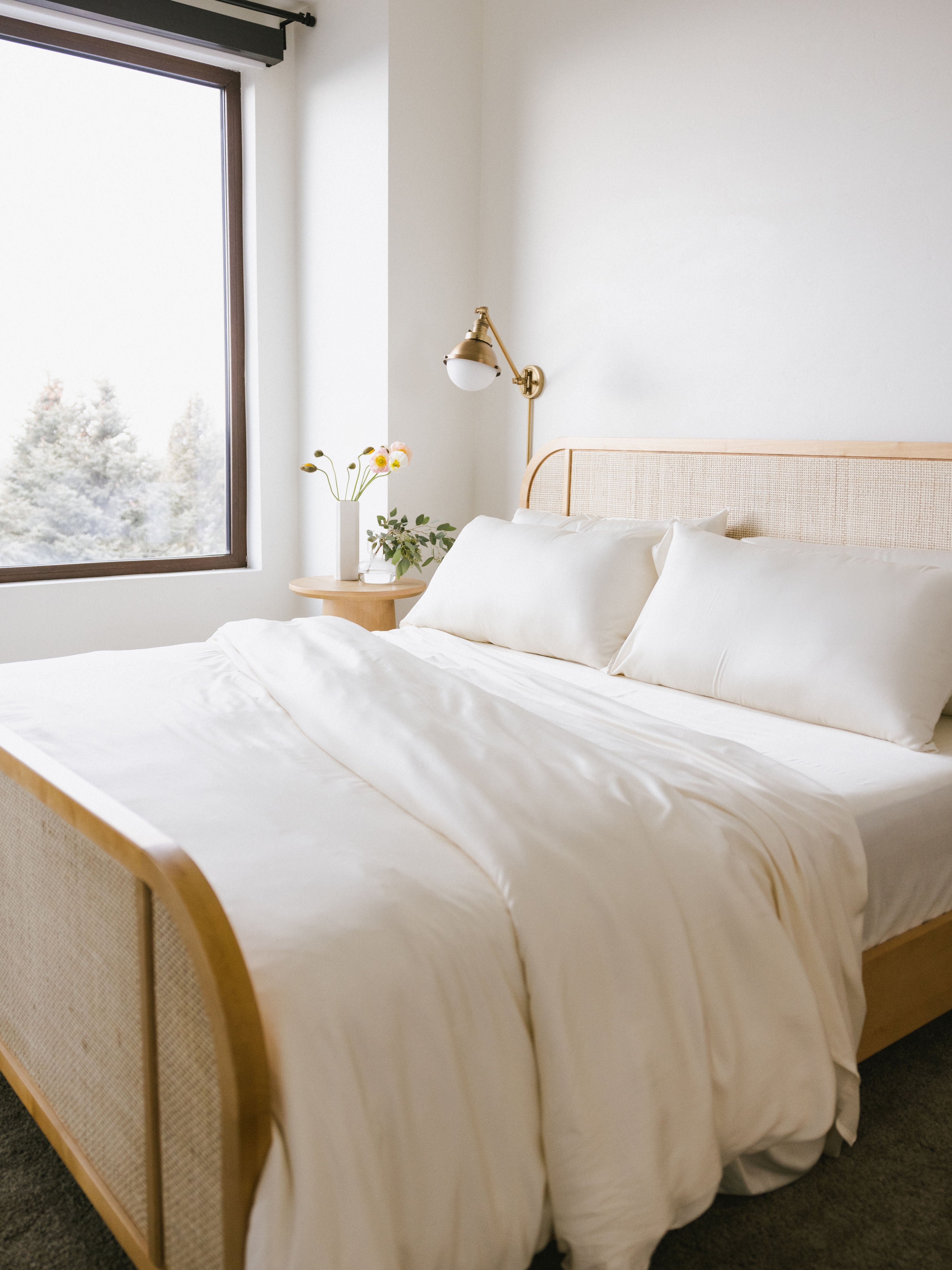 Partially made bed with creme bedding 