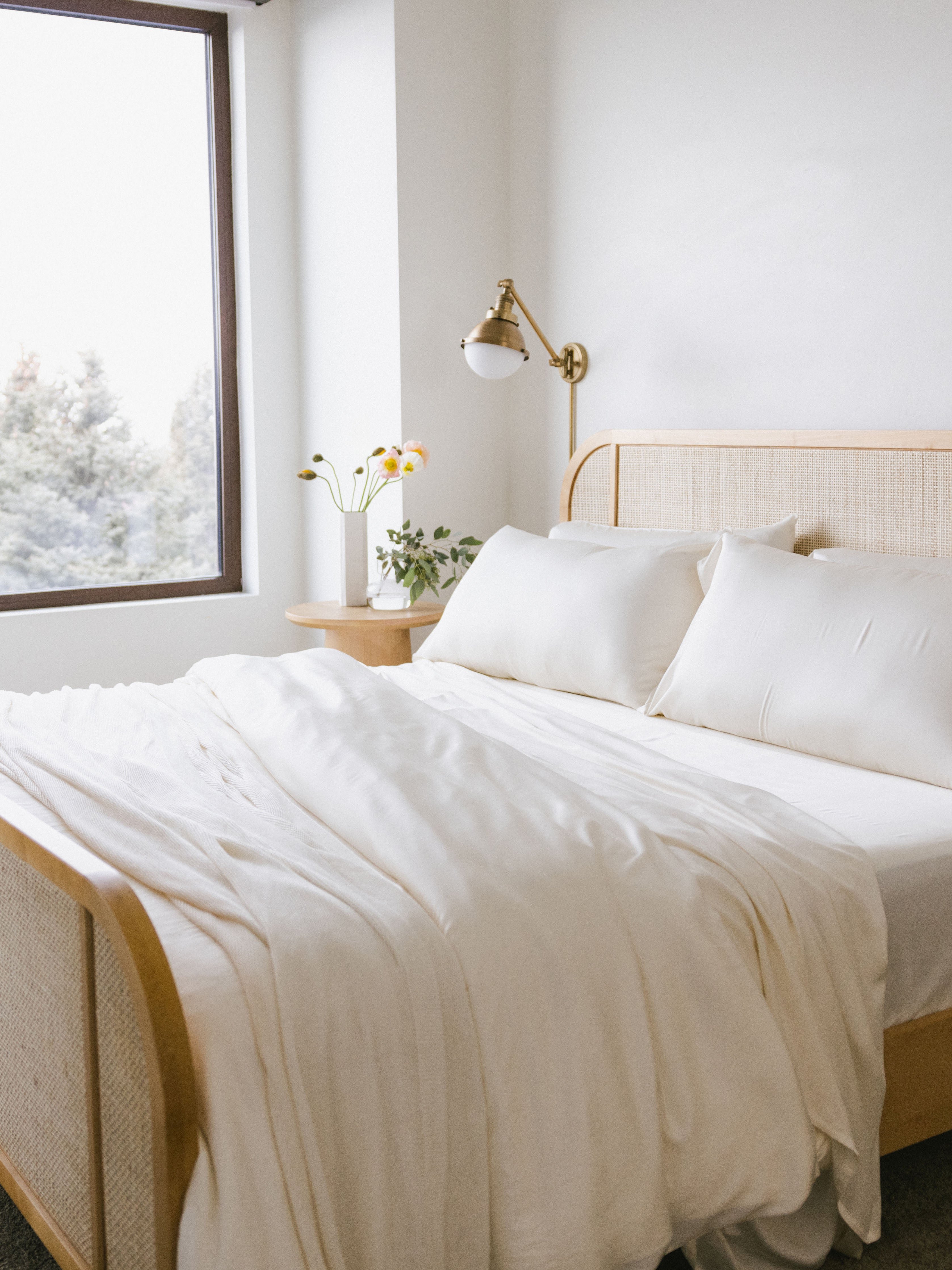 Zoomed out image of a whole bed with creme bedding 