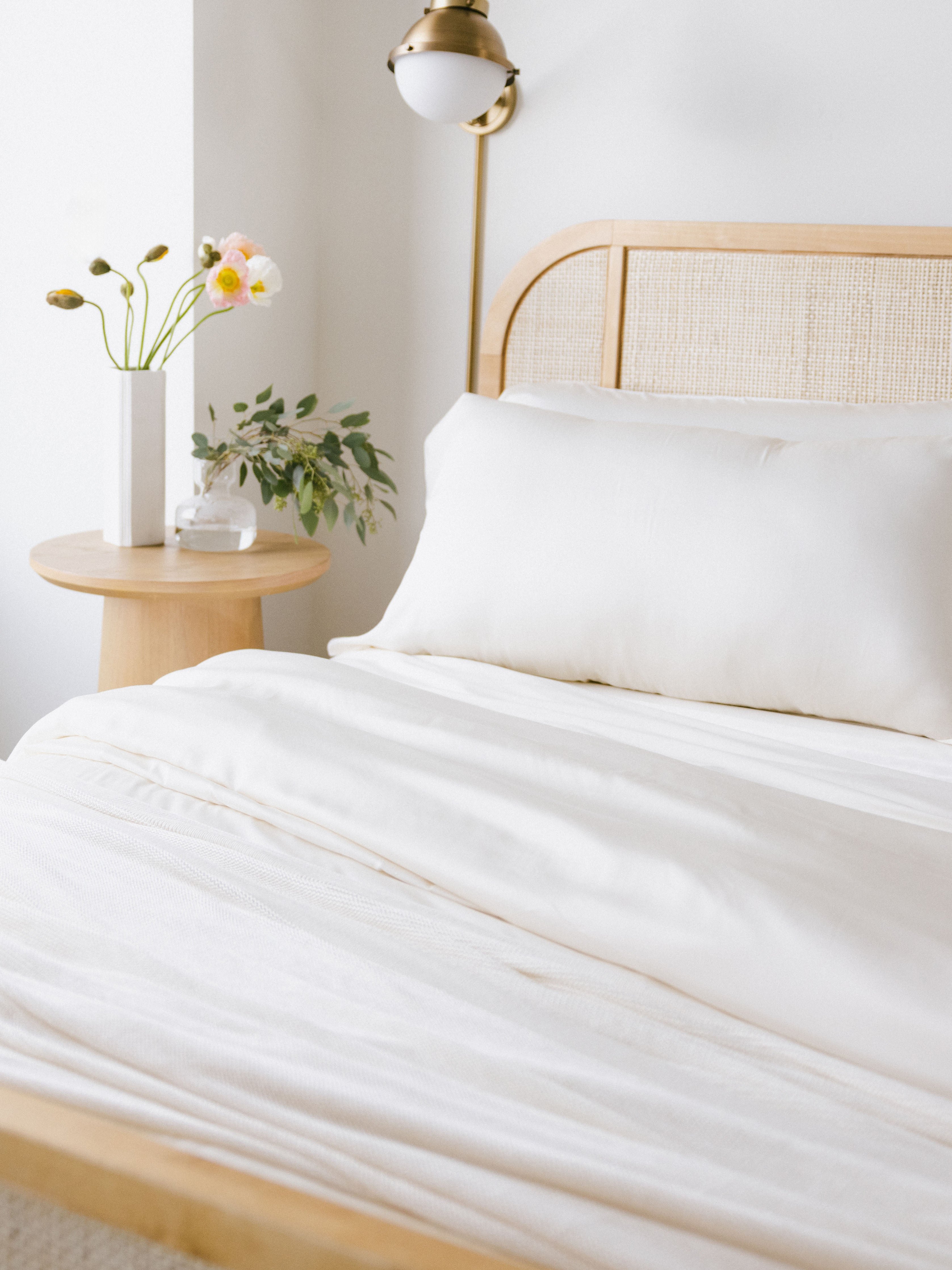 Partially made bed with creme bedding 