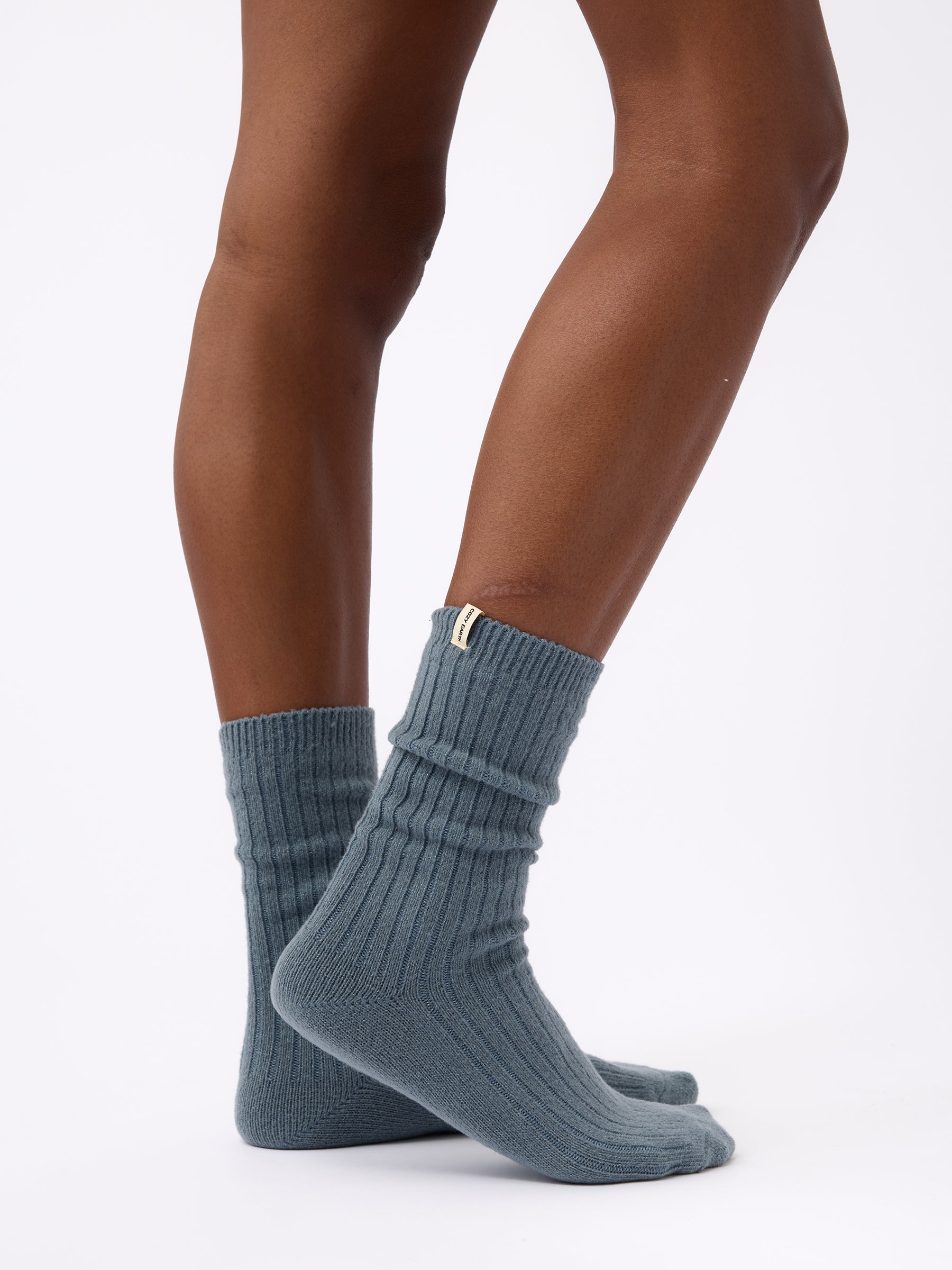 Person turned to the side wearing Cozy Earth Plush Lounge Calf Sock 1-Pack  in Deep Blue 