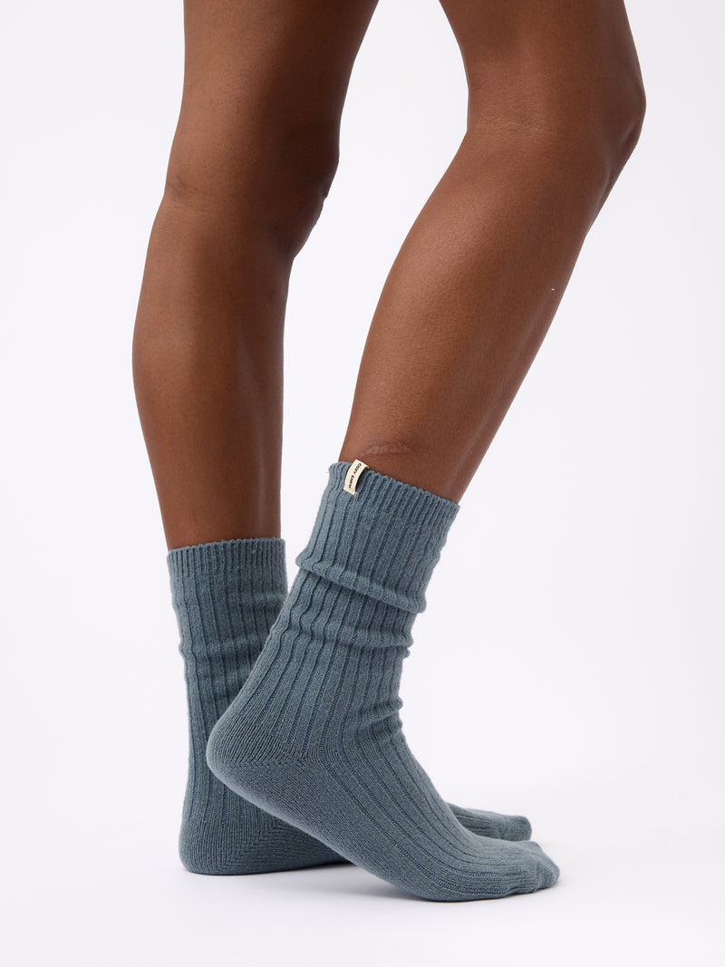 Person turned to the side wearing Cozy Earth Plush Lounge Calf Sock 1-Pack  in Deep Blue