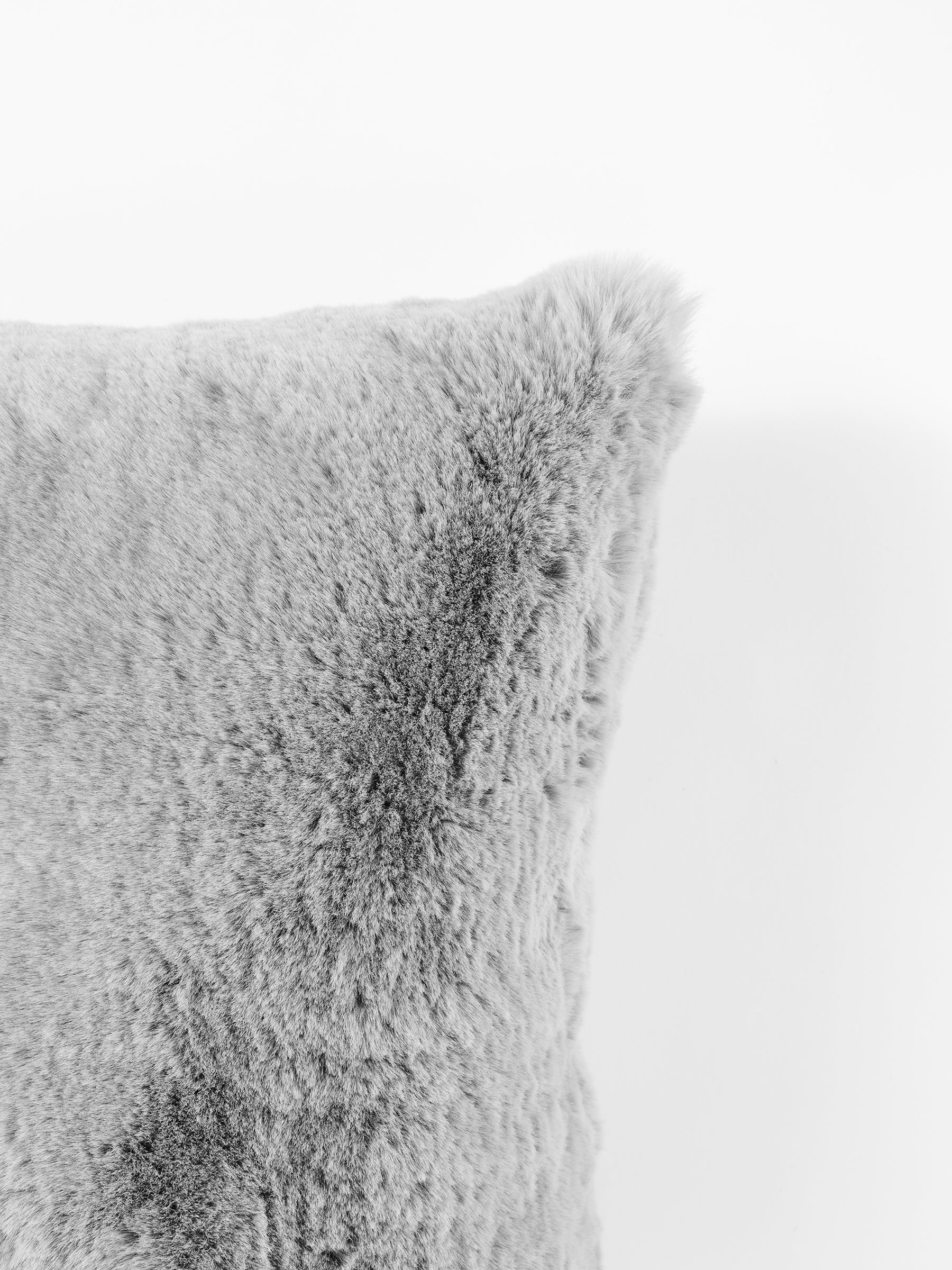 Close-up of the Cuddle Pillow from Cozy Earth, featuring its soft, fluffy gray surface against a white background. The texture appears plush and cozy, showcasing a visibly dense pile. |Color:Dove Grey