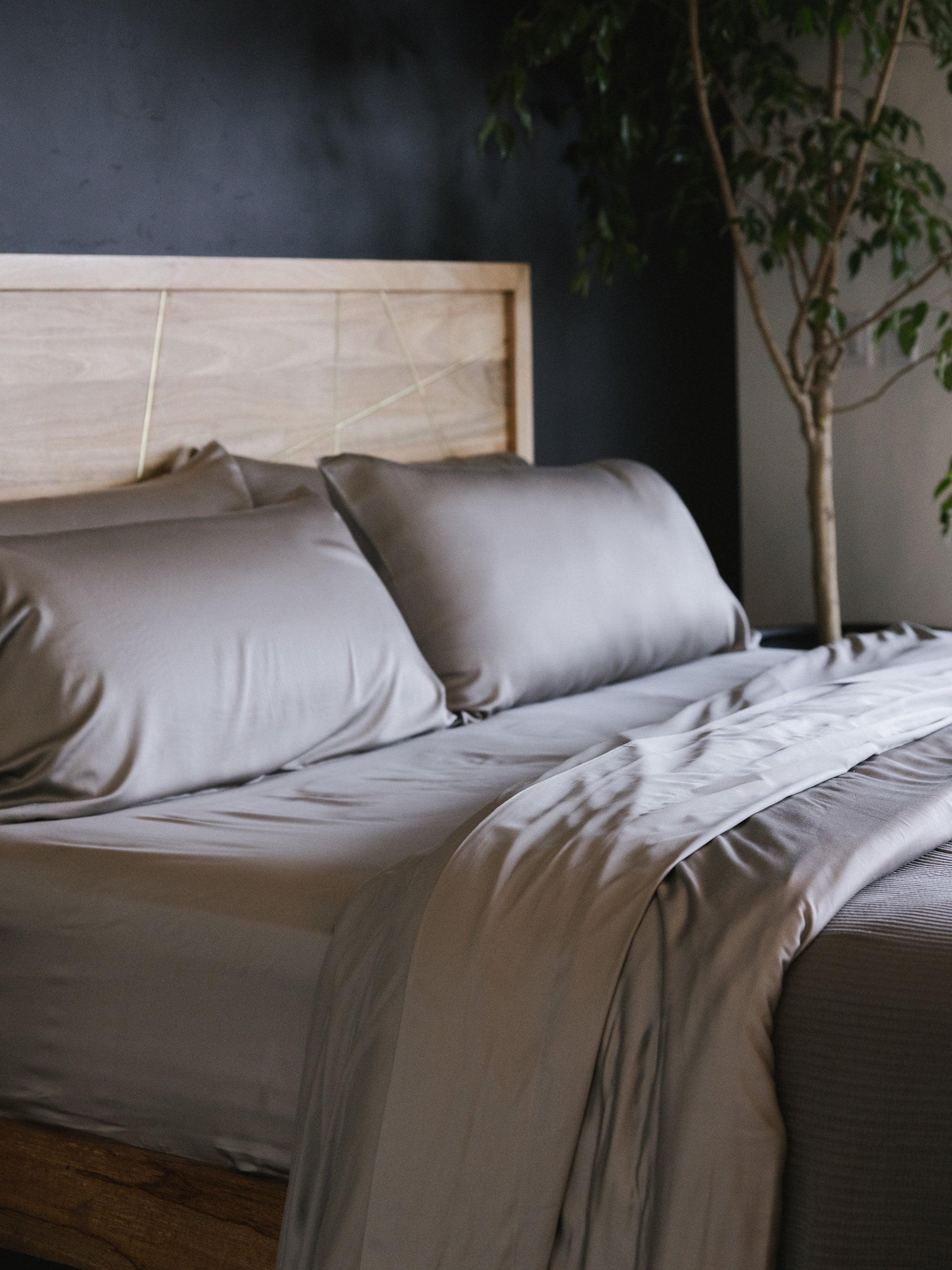 Bed made with dove grey bedding with tree in the background standard/king/body 