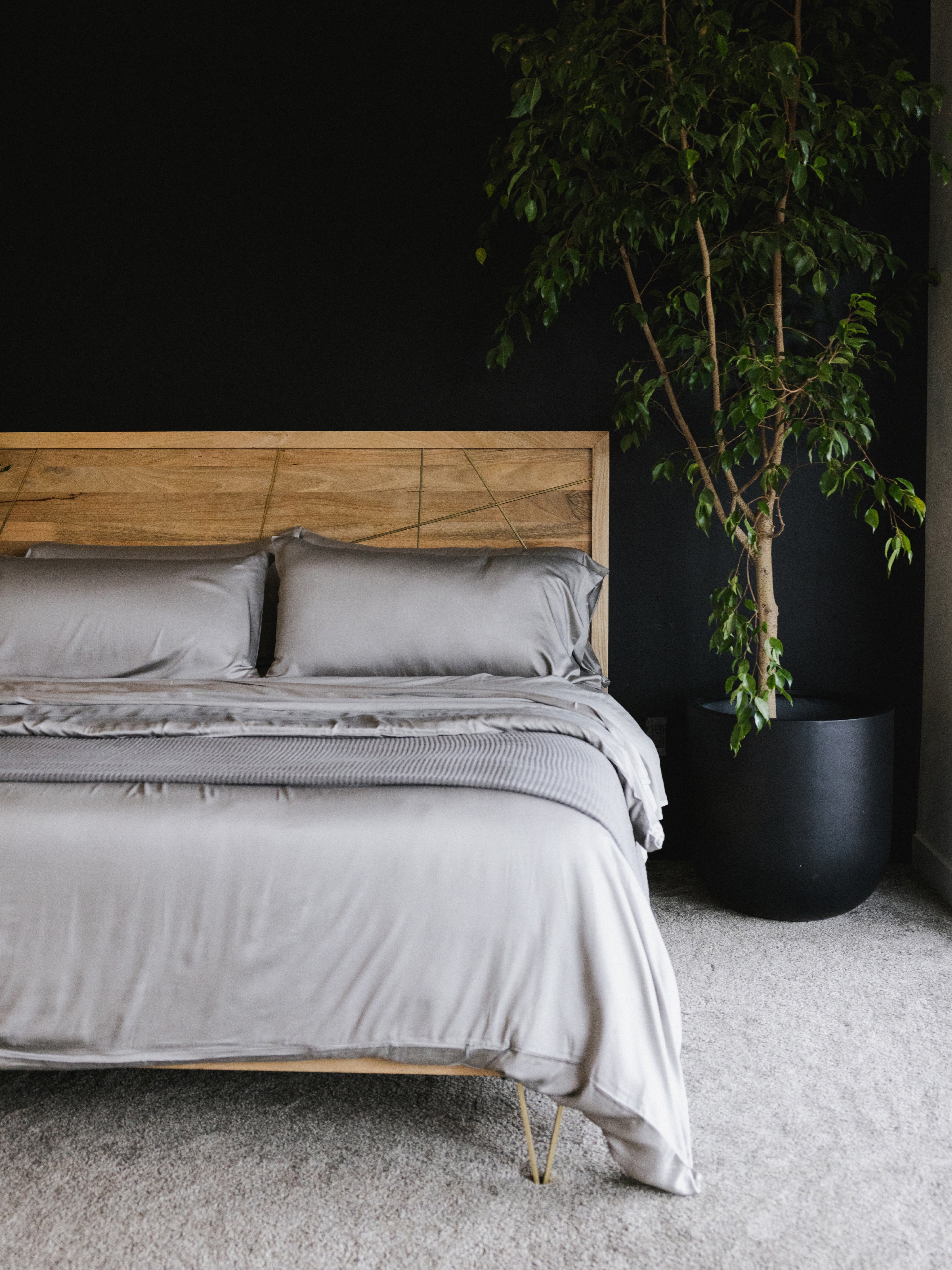 Zoomed out image of bed made with dove grey bedding 