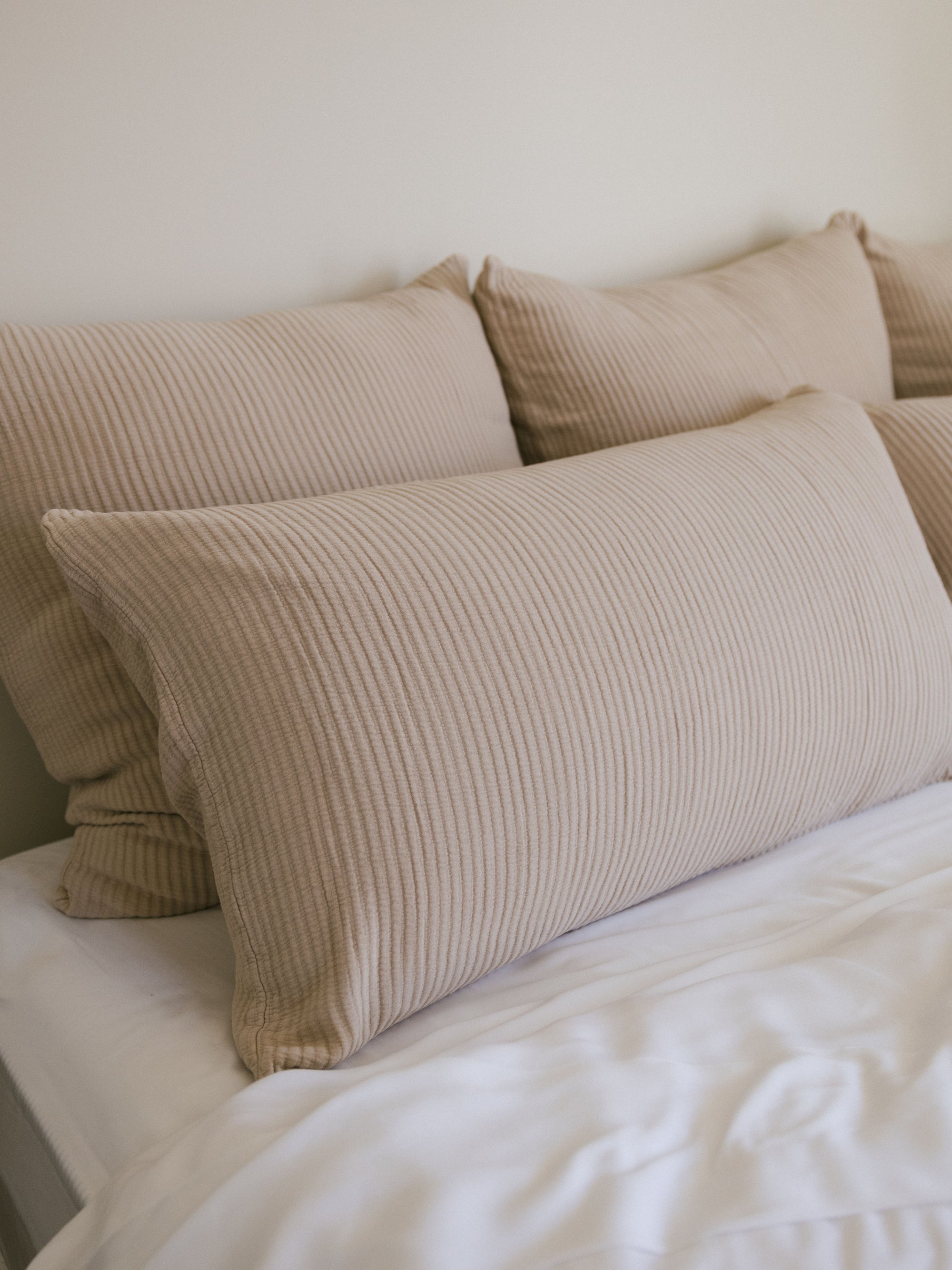 Driftwood coverlet shams on a white bed 