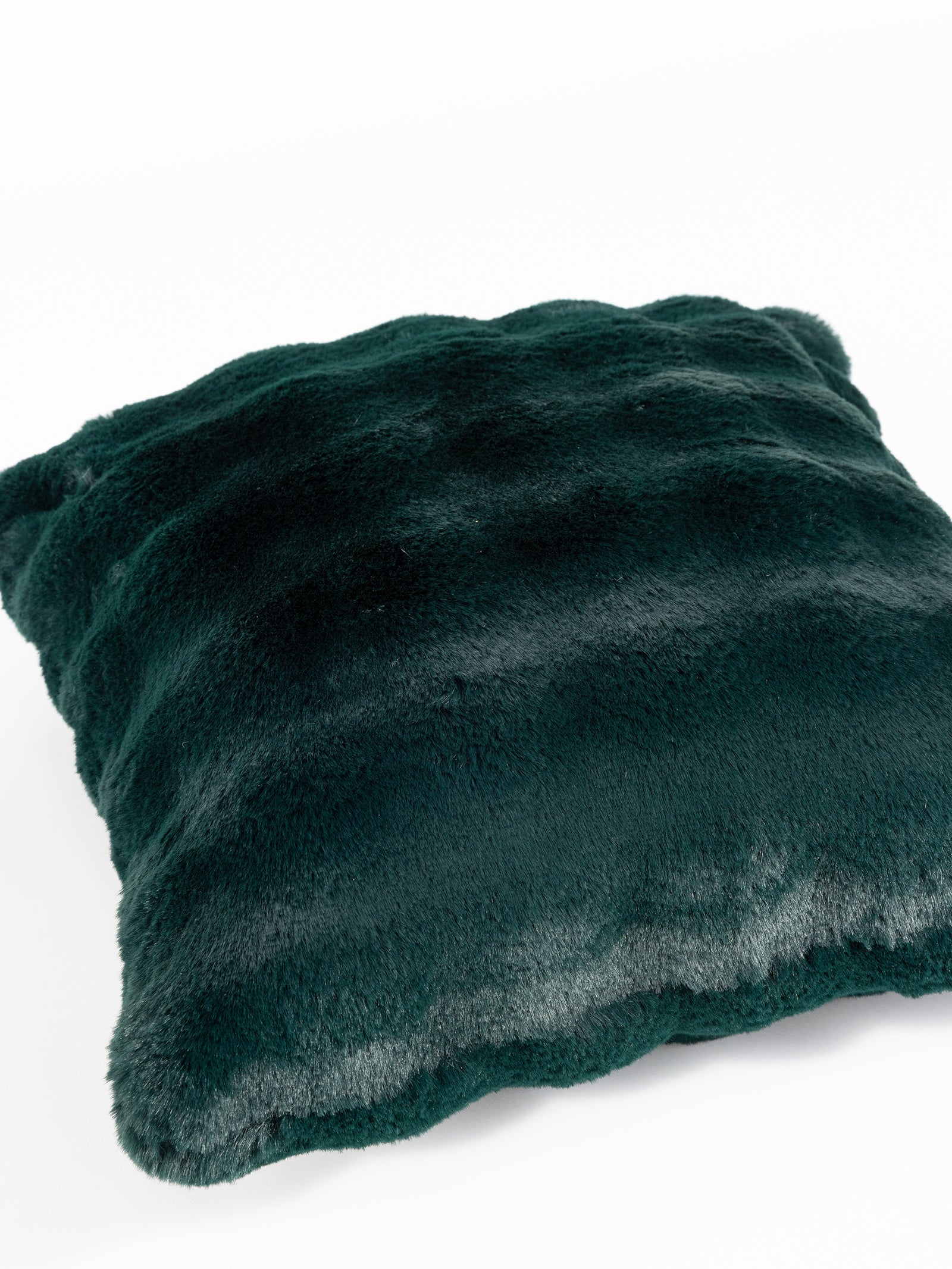 The Bubble Cuddle Pillow from Cozy Earth, in a rich dark green color, showcases a soft, plush texture akin to fur and is set against a white background. Its surface features subtle shading, enhancing its luxurious, velvety appearance. 