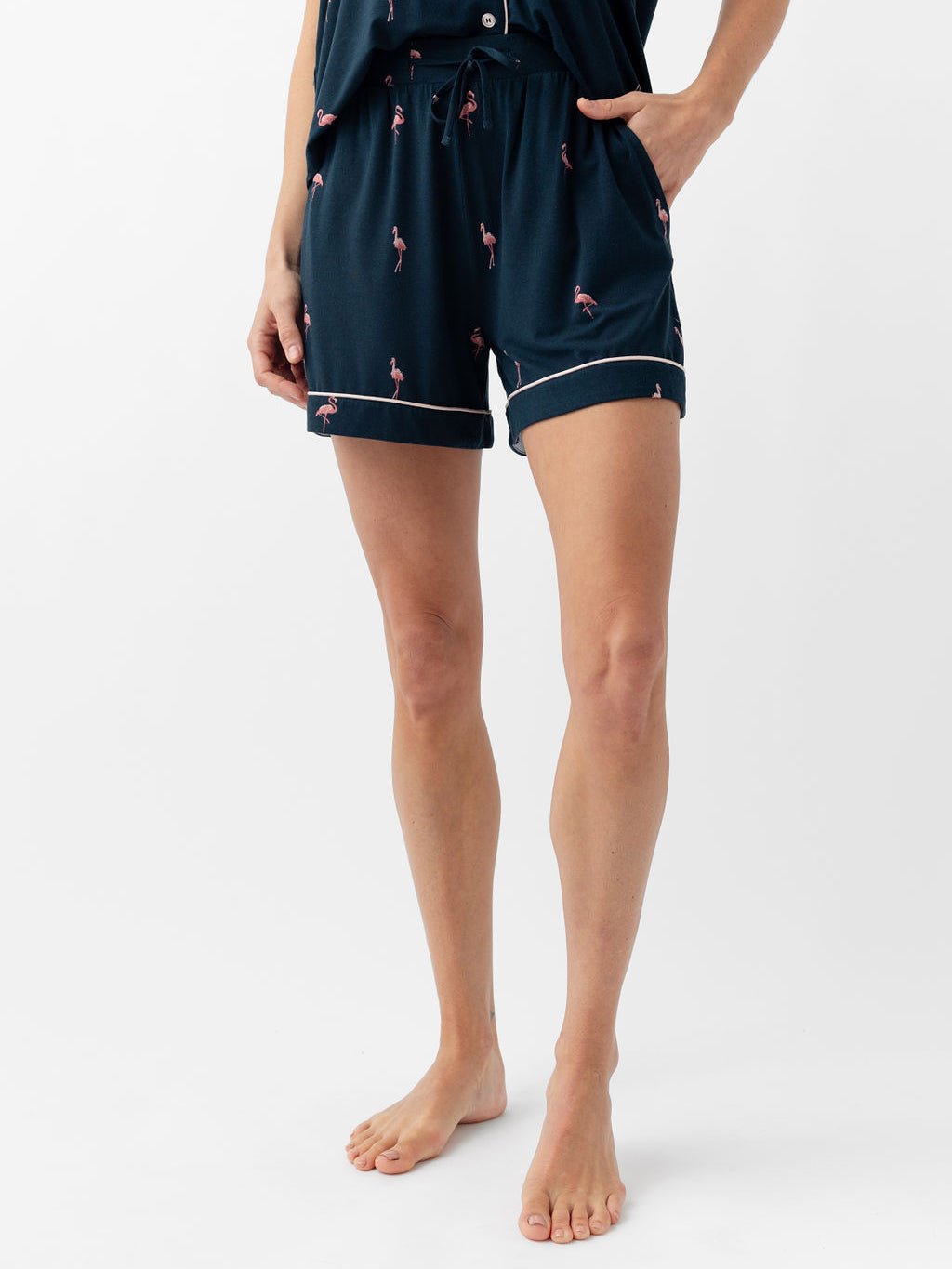 Woman wearing flamingo print pajama shorts with white background 