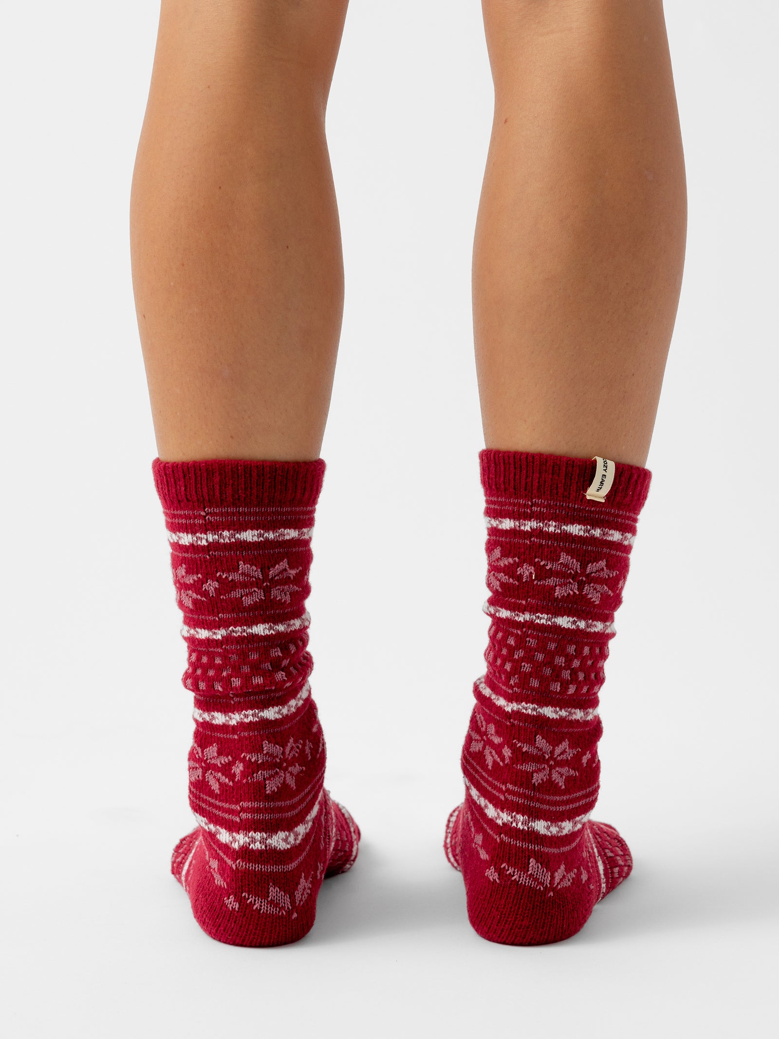 A person stands facing backwards with a white background wearing Snowflake Plush Lounge Sock in Garnet 