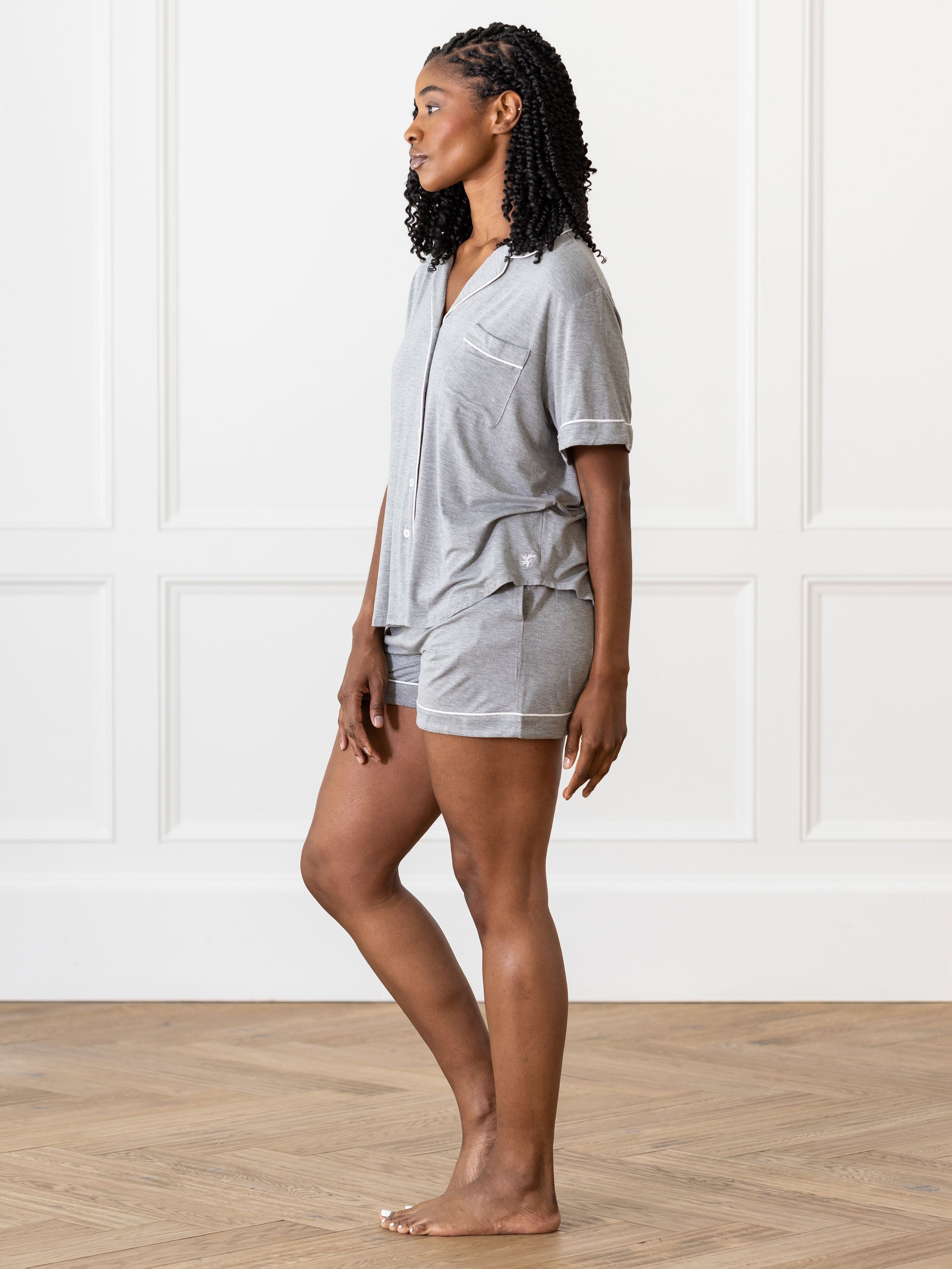 Grey Short Sleeve Pajama Set modeled by a woman. The photo was taken in a light setting, showing off the colors and lines of the pajamas. 