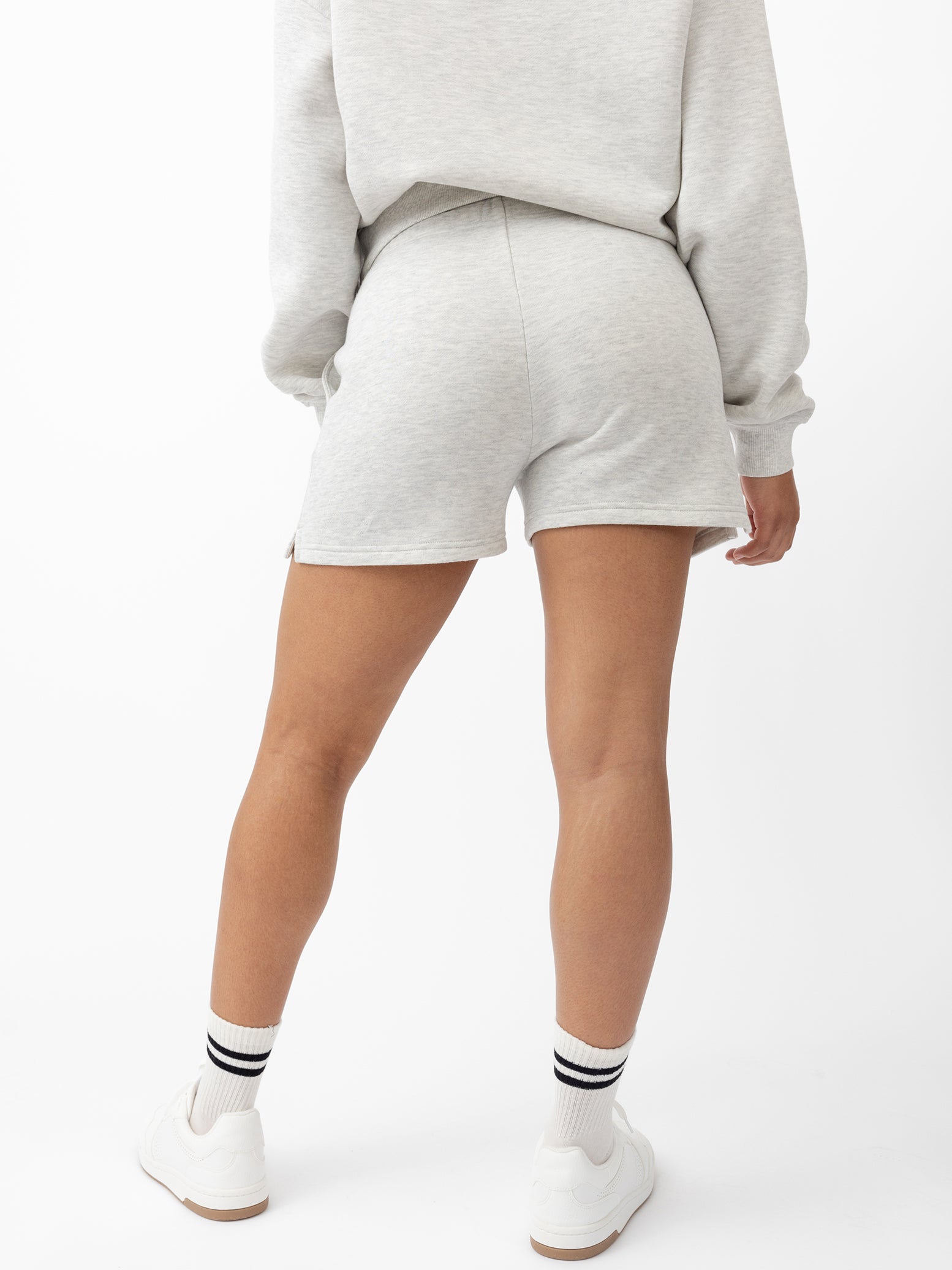 Heather Grey CityScape Shorts. The shorts are being worn by a female model in skate shoes. The background it a white background. 