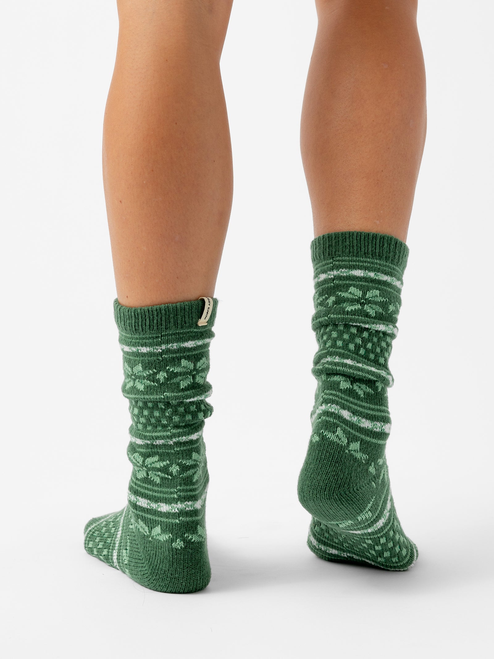 A person facing backwards stands with a white background wearing Snowflake Plush Lounge Sock in Jade 