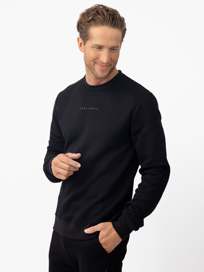 Man wearing black cityscape pullover with white background