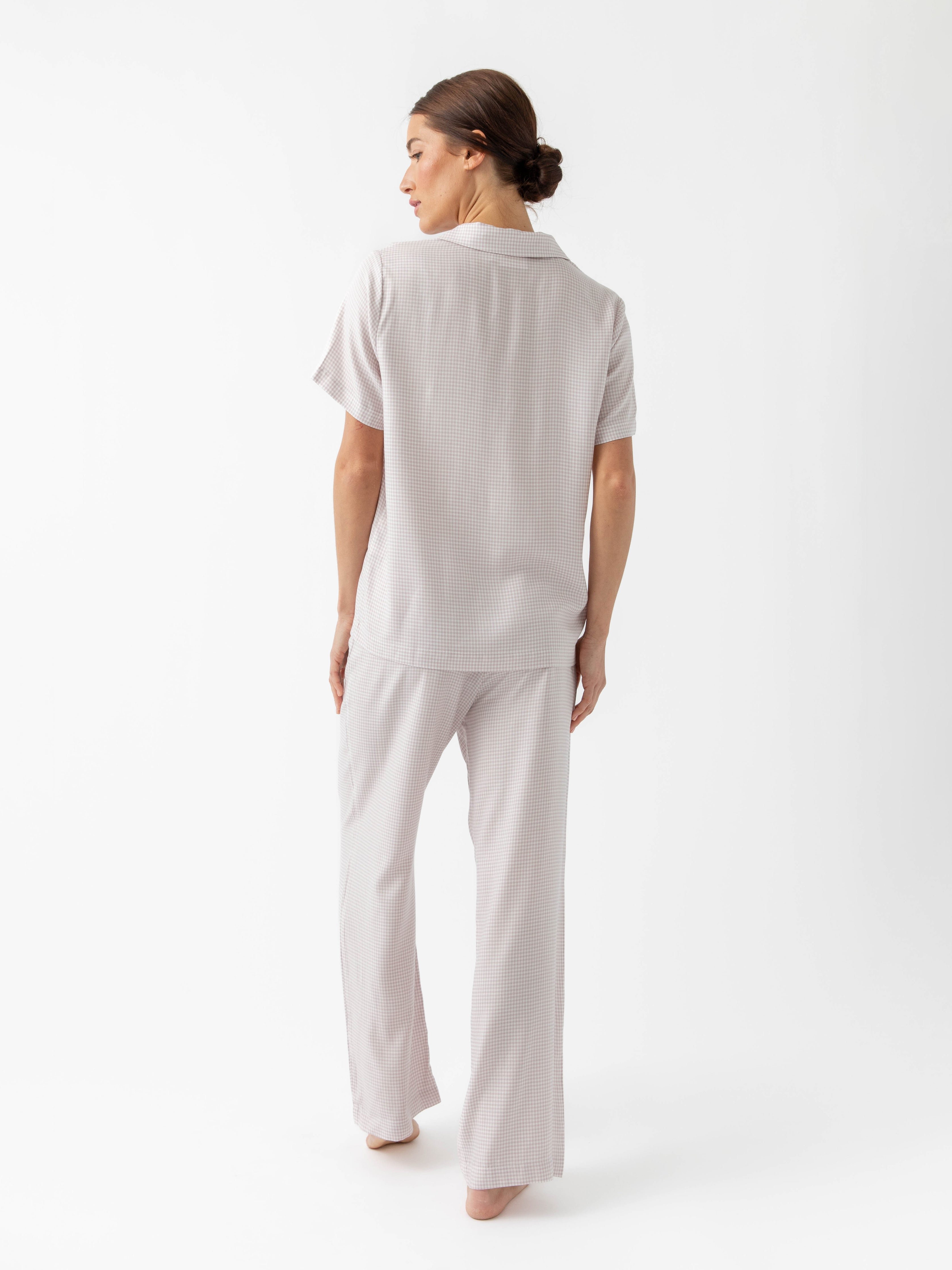 Back of woman in lavender mini gingham pajama set with white background 