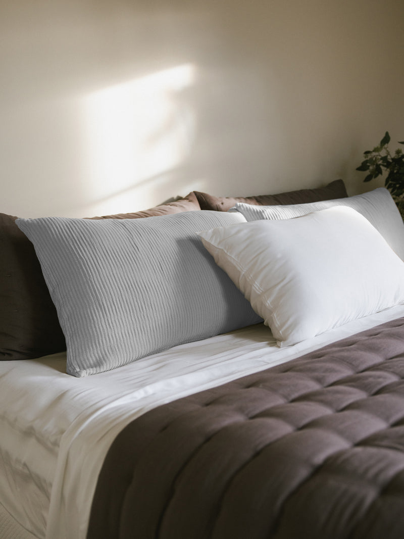 Light Grey coverlet shams on bed with linen puckered quilt and shams