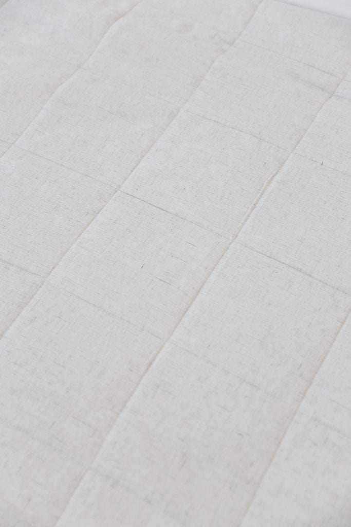 Close up of Light Grey Linen Box Quilt Sham laying flat. 
