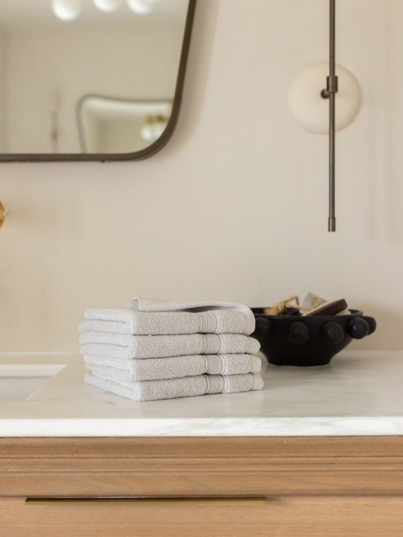 Light grey washcloths folded on bathroom counter
