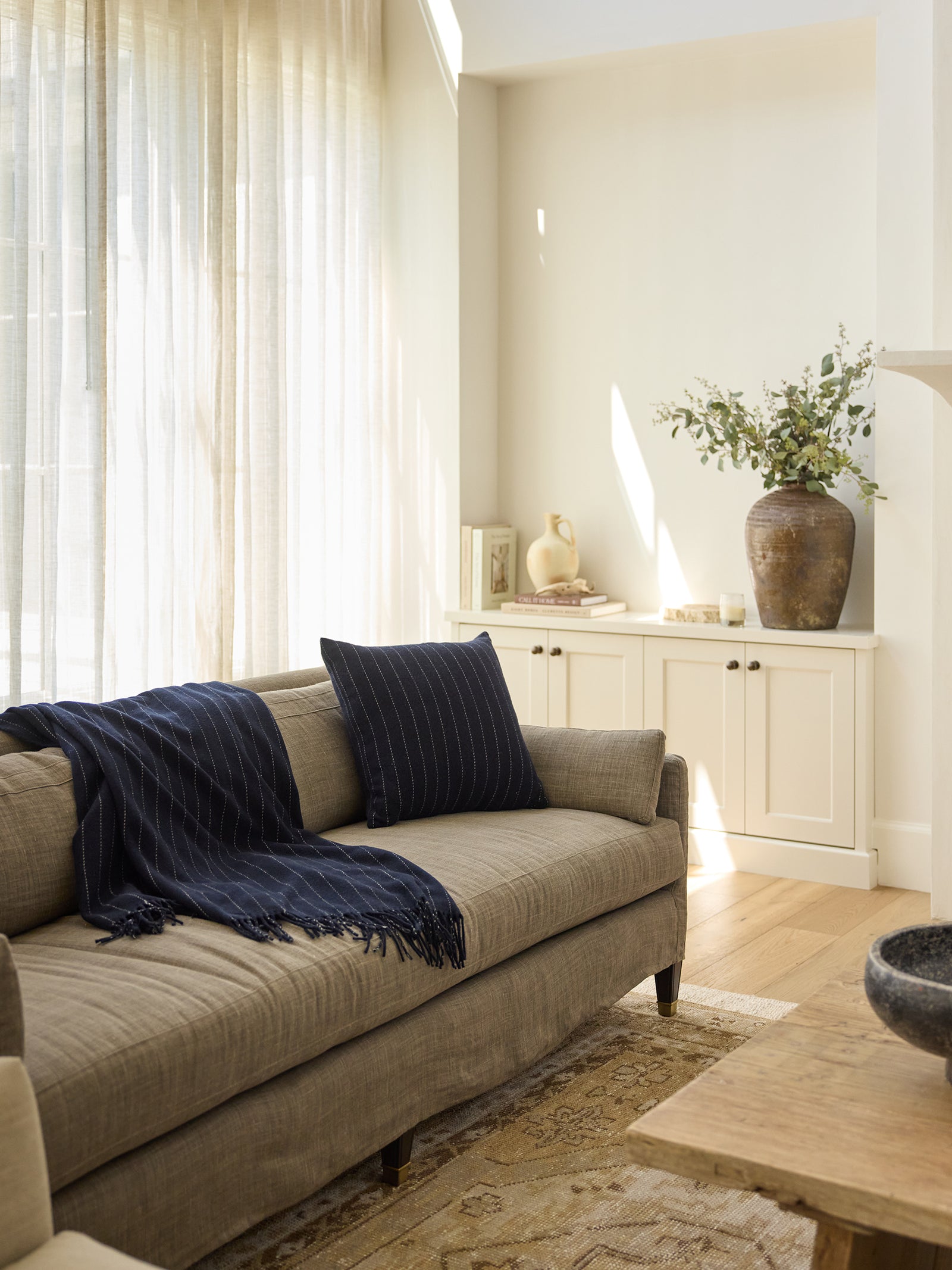 Picture of living room with florence pillow and blanket rested on sofa 