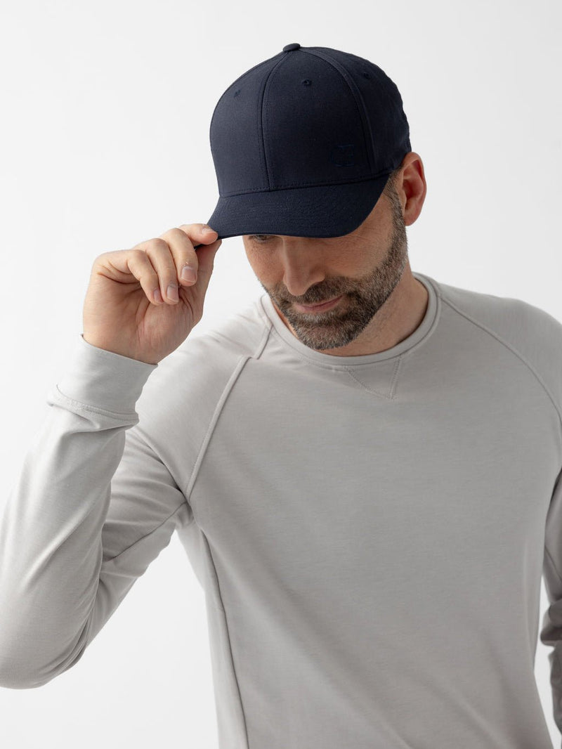 Man wearing navy urban classic hat looking down