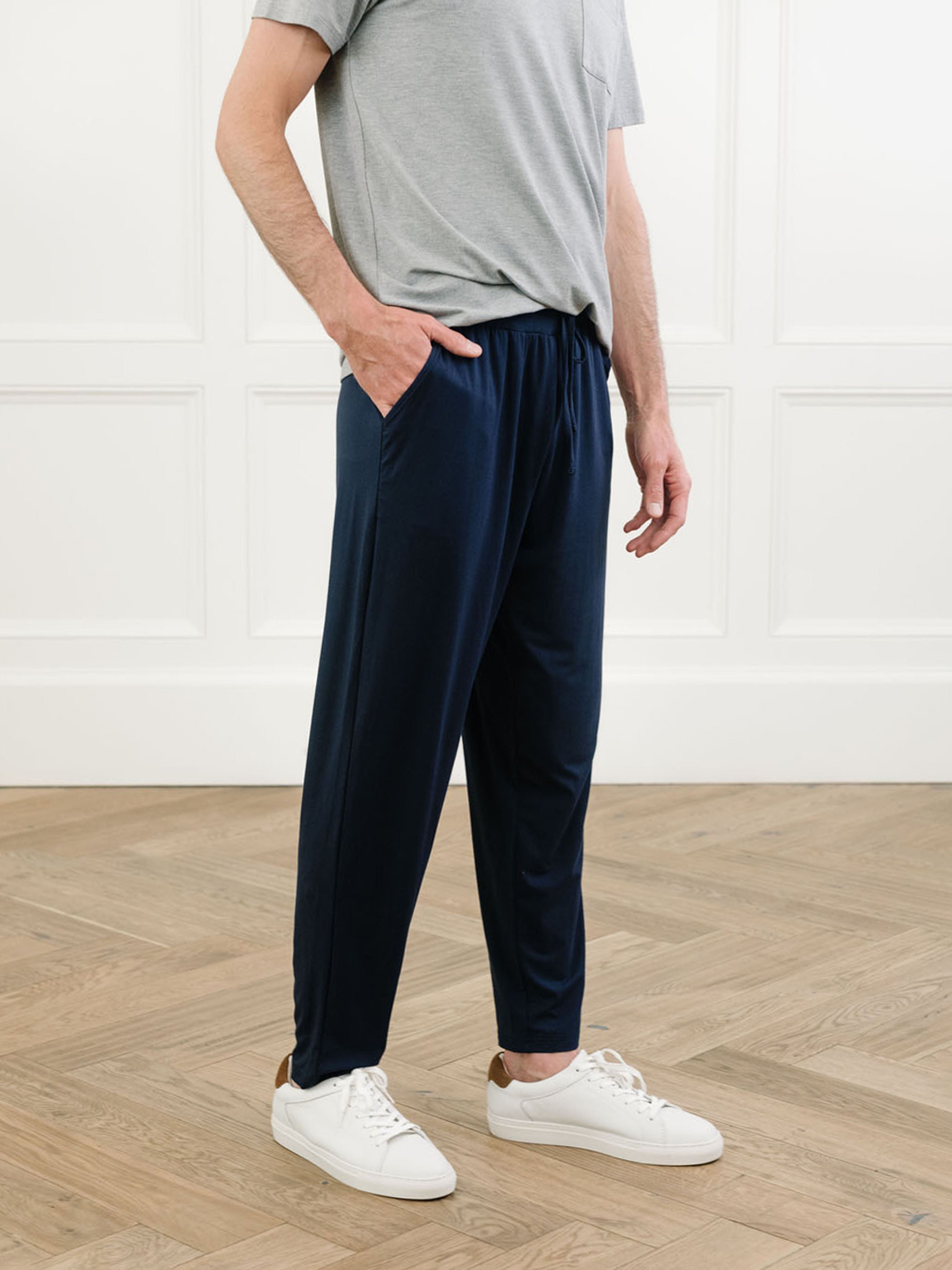 Man in navy pajama pants in room with wooden floor 