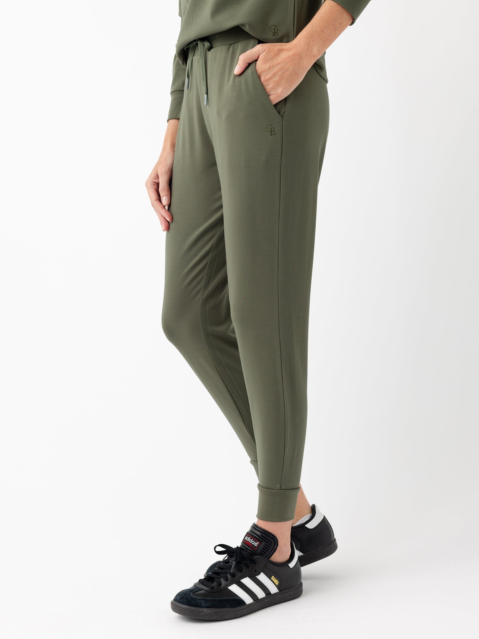 Woman in olive joggers with white background 
