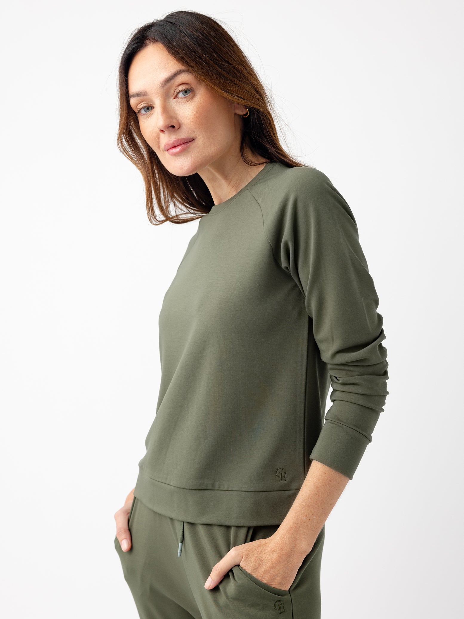 Woman in olive crewneck with white background 
