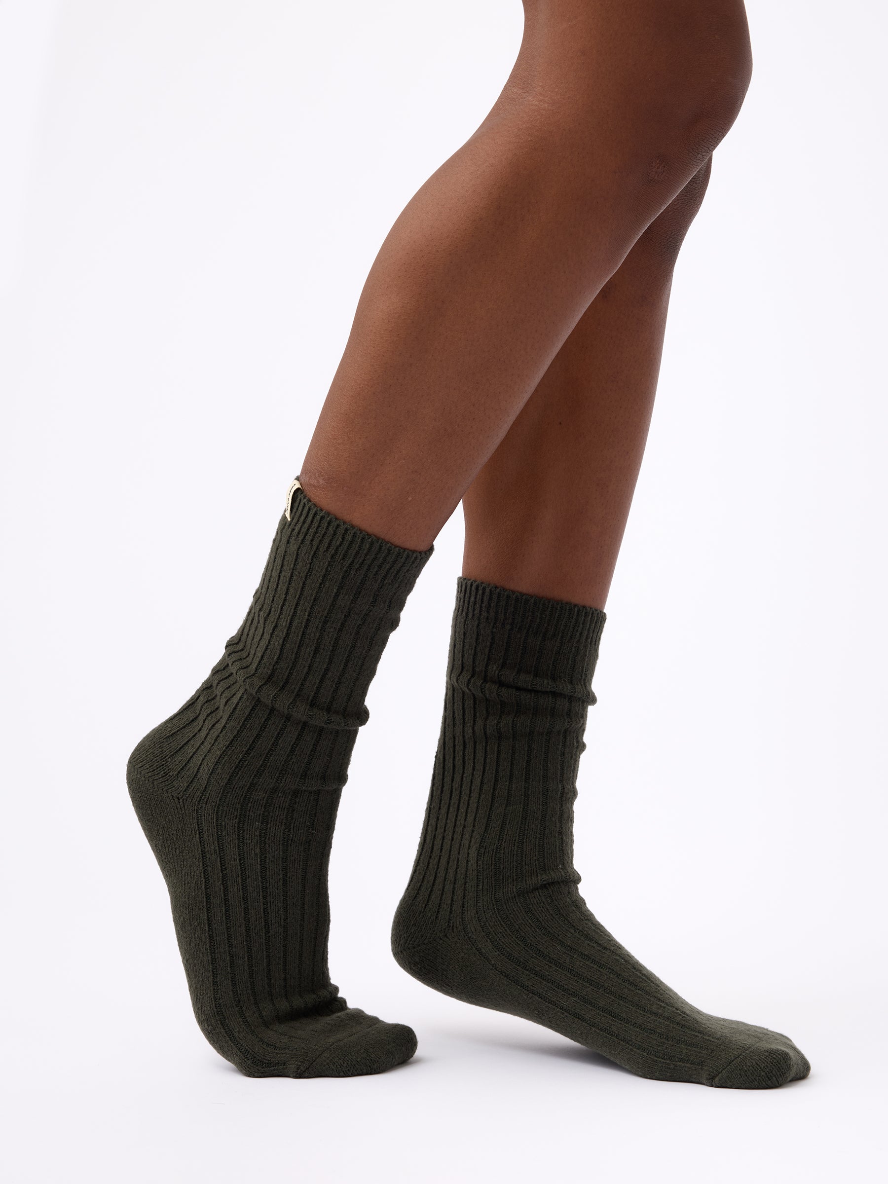 Person wearing Cozy Earth Plush Lounge Calf Sock in Pine 