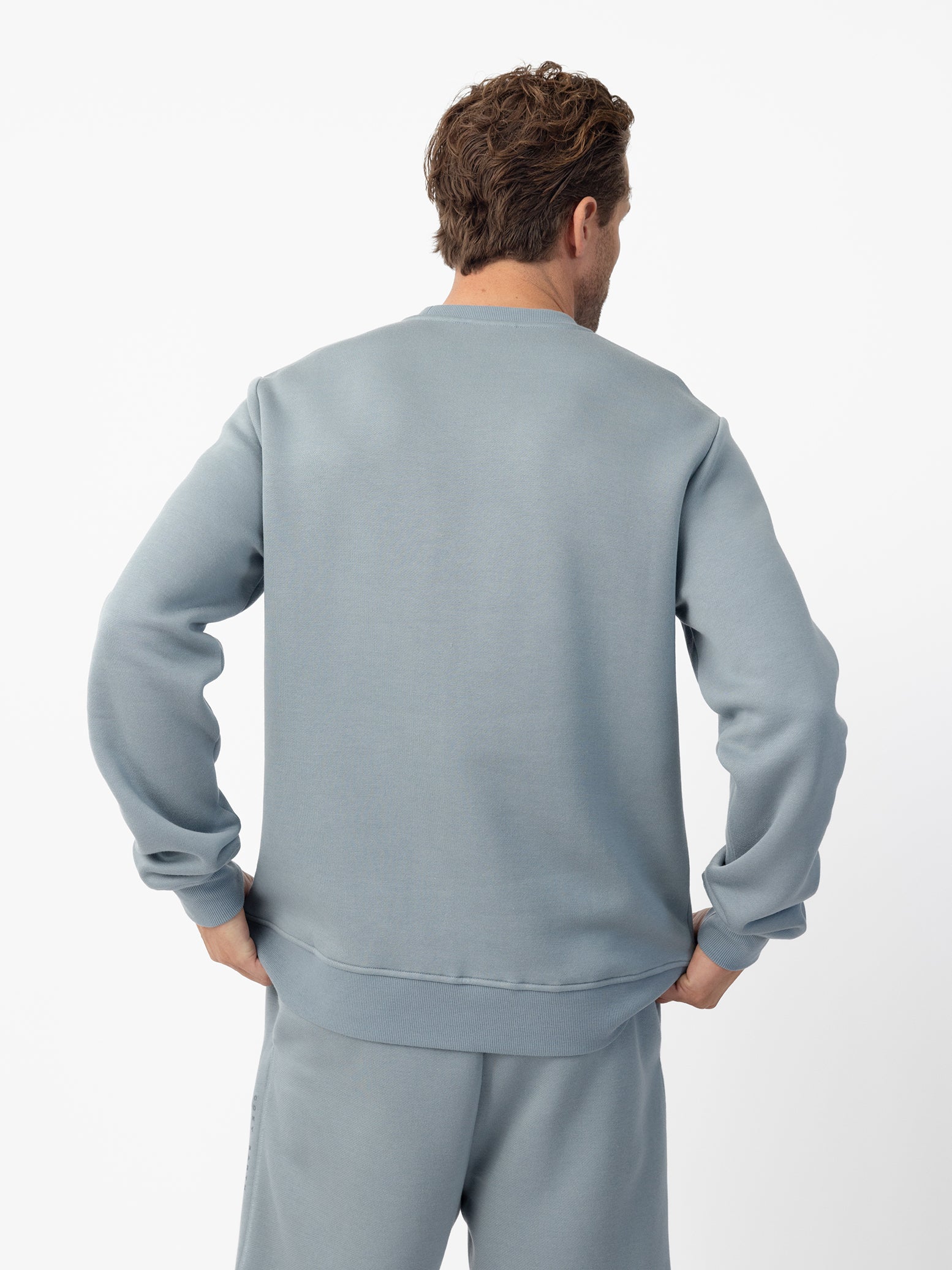 Man wearing Smokey Blue cityscape crewneck with white background 