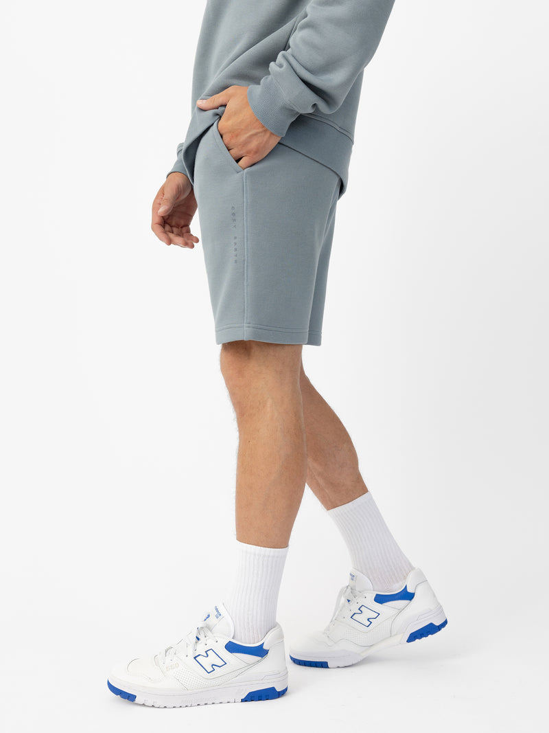 Man wearing Smokey Blue CityScape Shorts with white background