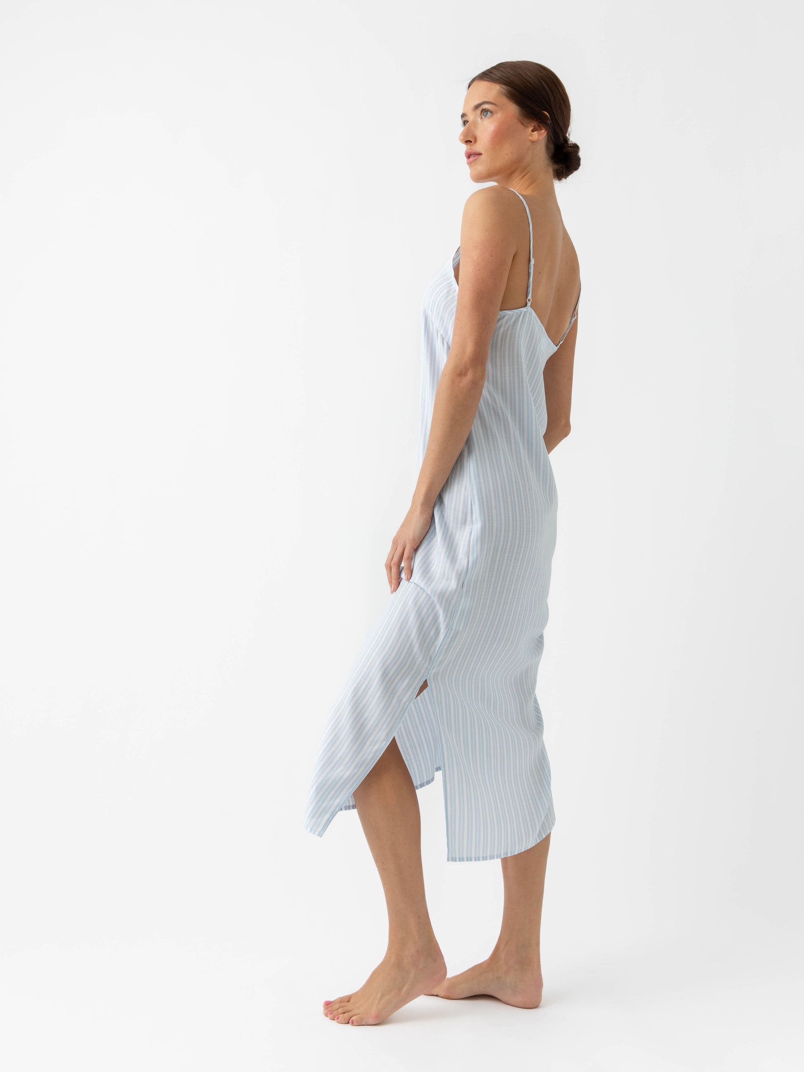 Woman in Spring Blue Stripe nightgown standing in front of white background 