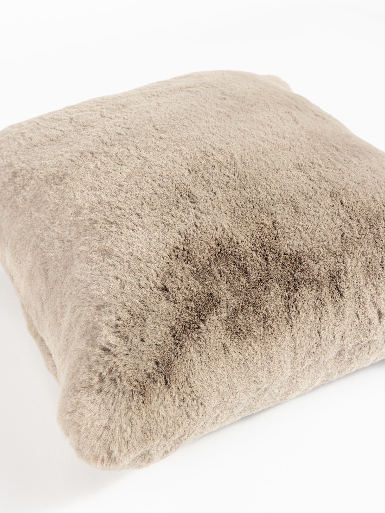 The Cuddle Pillow by Cozy Earth is a soft, square cushion featuring a fluffy beige faux fur cover set against a white background. 