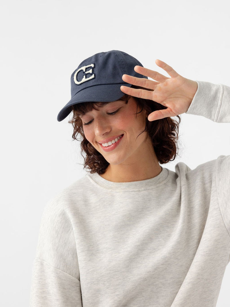 Woman looking down wearing washed navy vintage cap