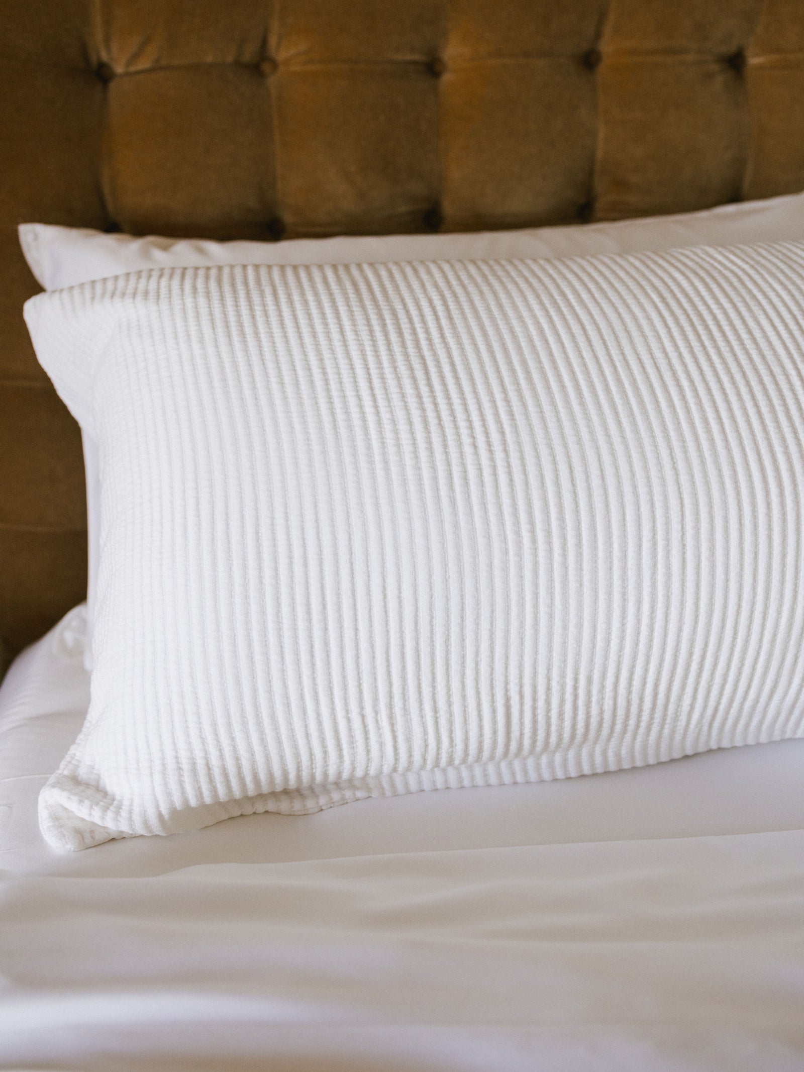 White coverlet sham on bed close up 