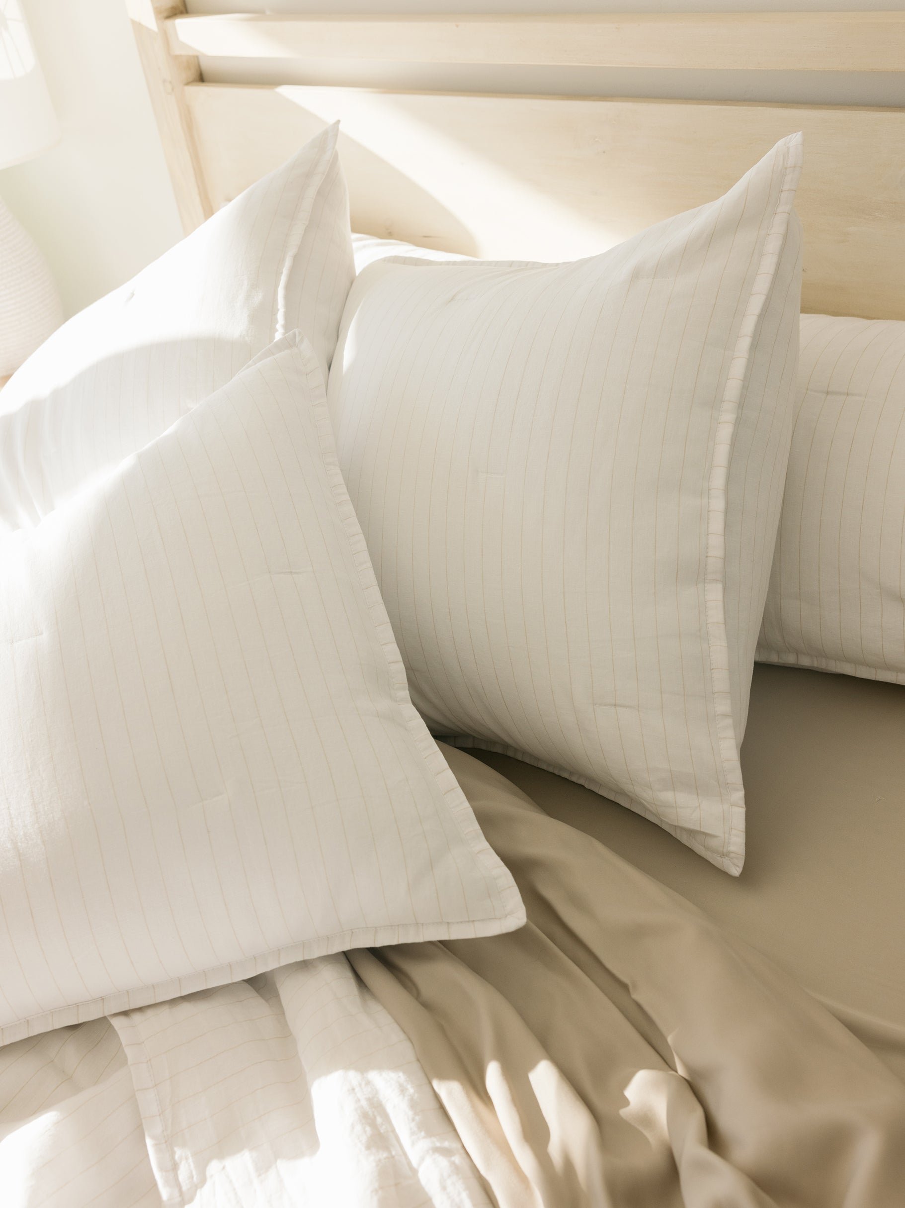 Close up of flax pencil stripe shams on bed 