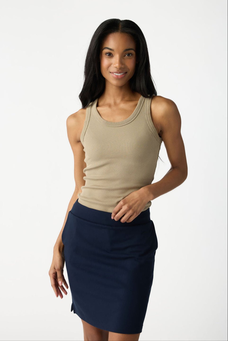 A woman with long black hair smiles while posing against a light background, wearing a beige sleeveless top and the Cozy Earth Women's Brushed Bamboo Skirt in navy. 