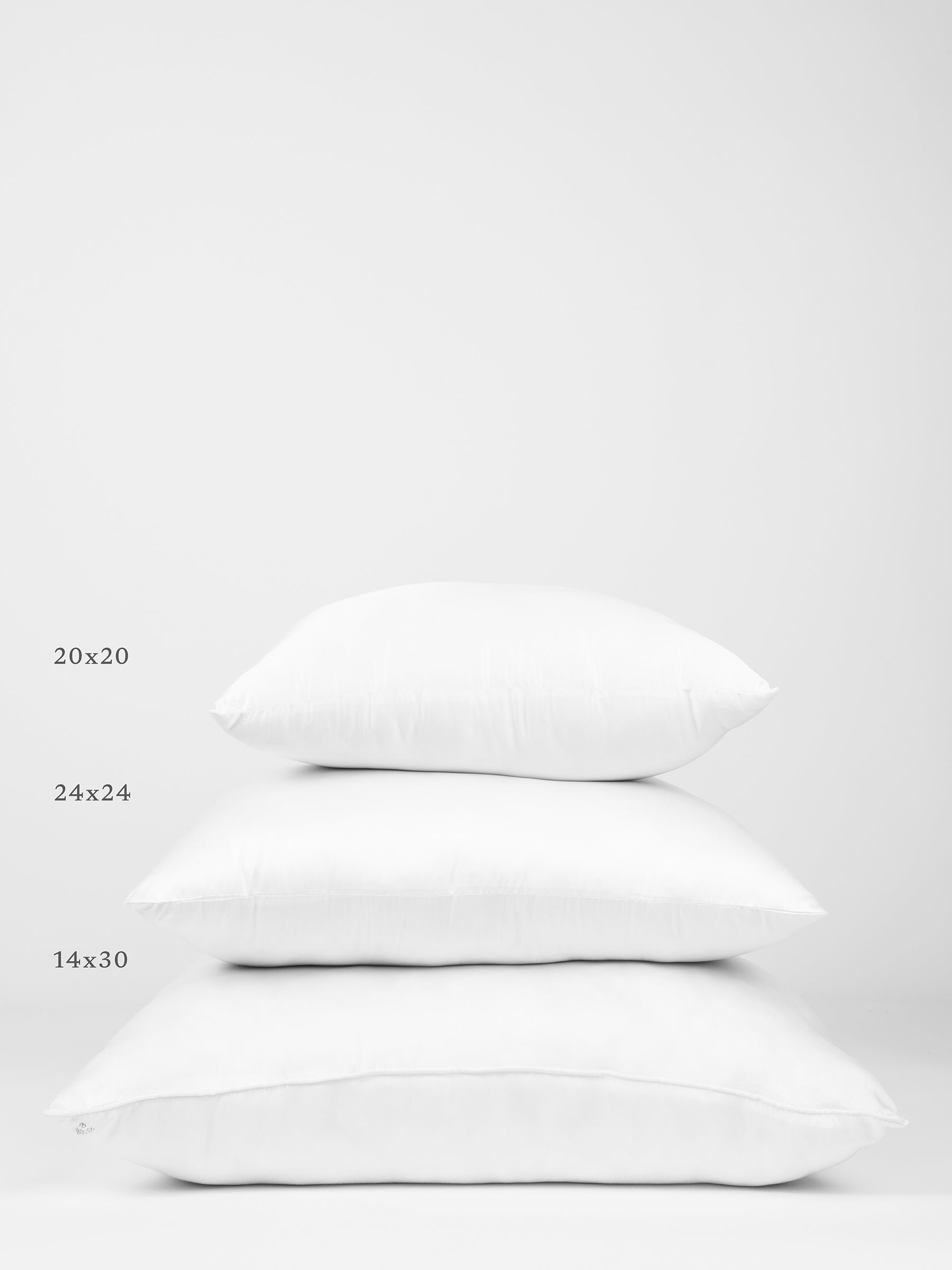 Three Cozy Earth Premium Down Alternative Inserts of different sizes are stacked on top of each other against a white background. The sizes are labeled on the left side as 20x20 (top), 24x24 (middle), and 14x30 (bottom). 
