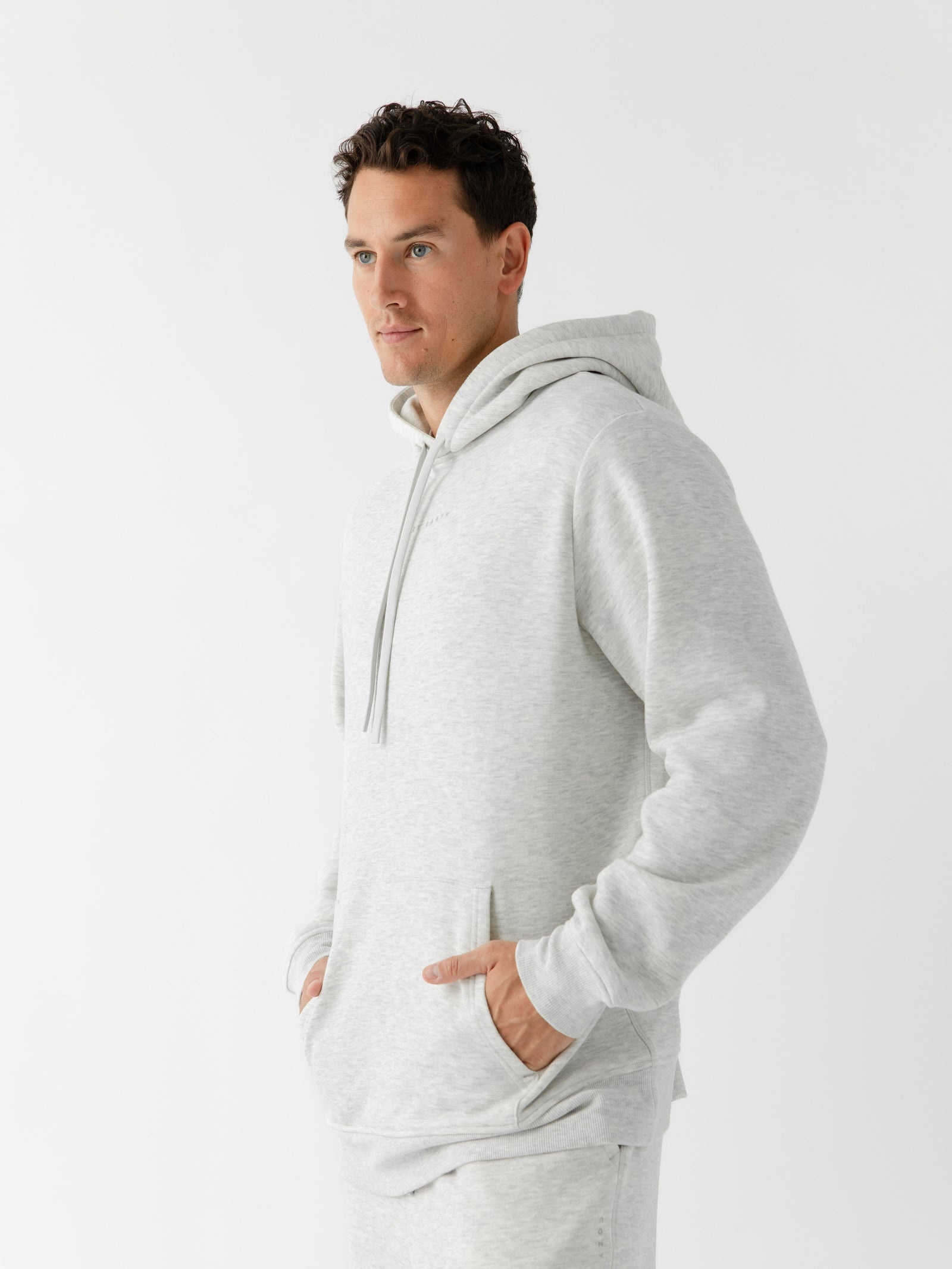 Man wearing heather grey cityscape hoodie with white background 