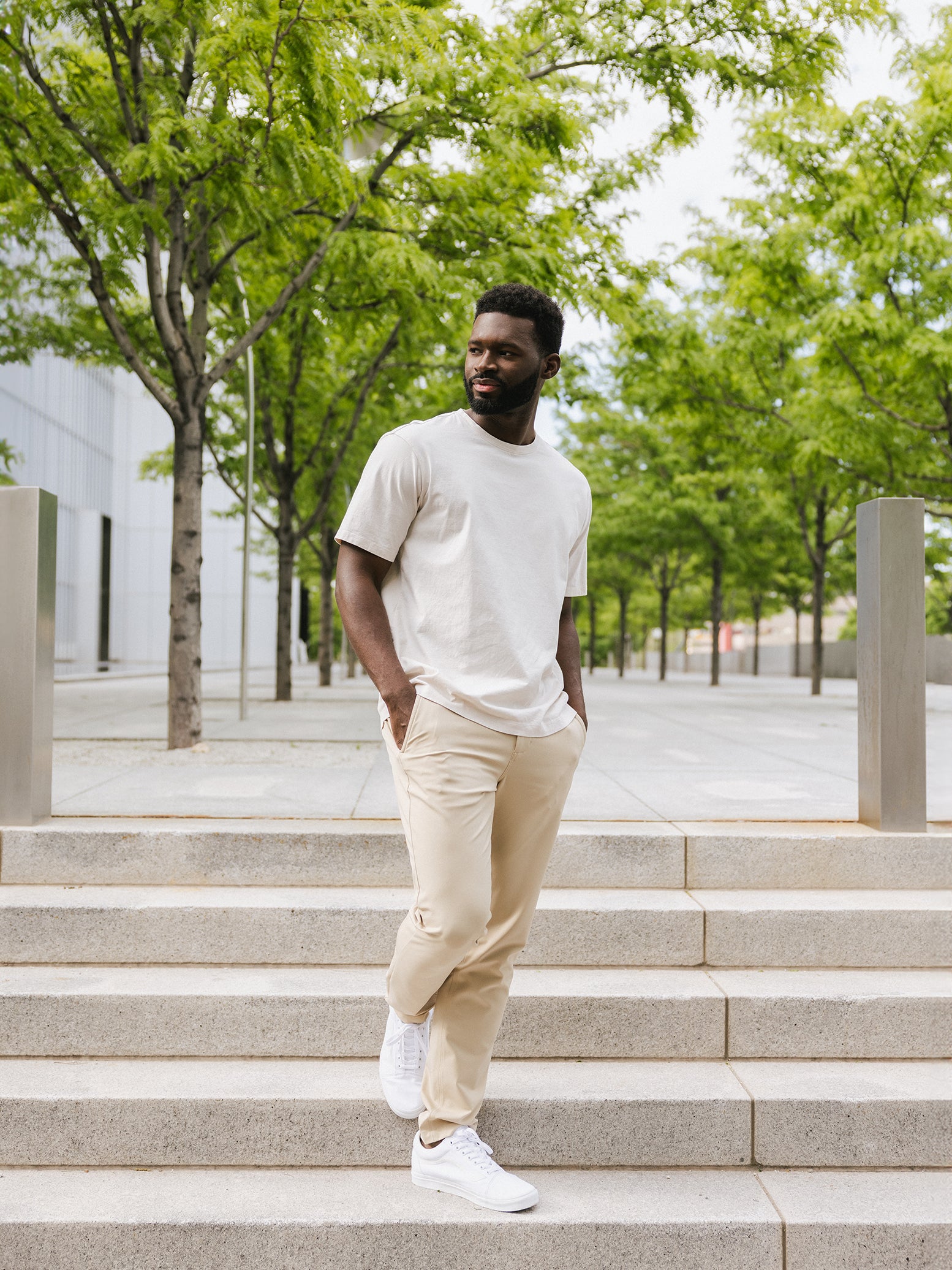 Man in alabaster tee and khaki pants on city steps |Color:Alabaster