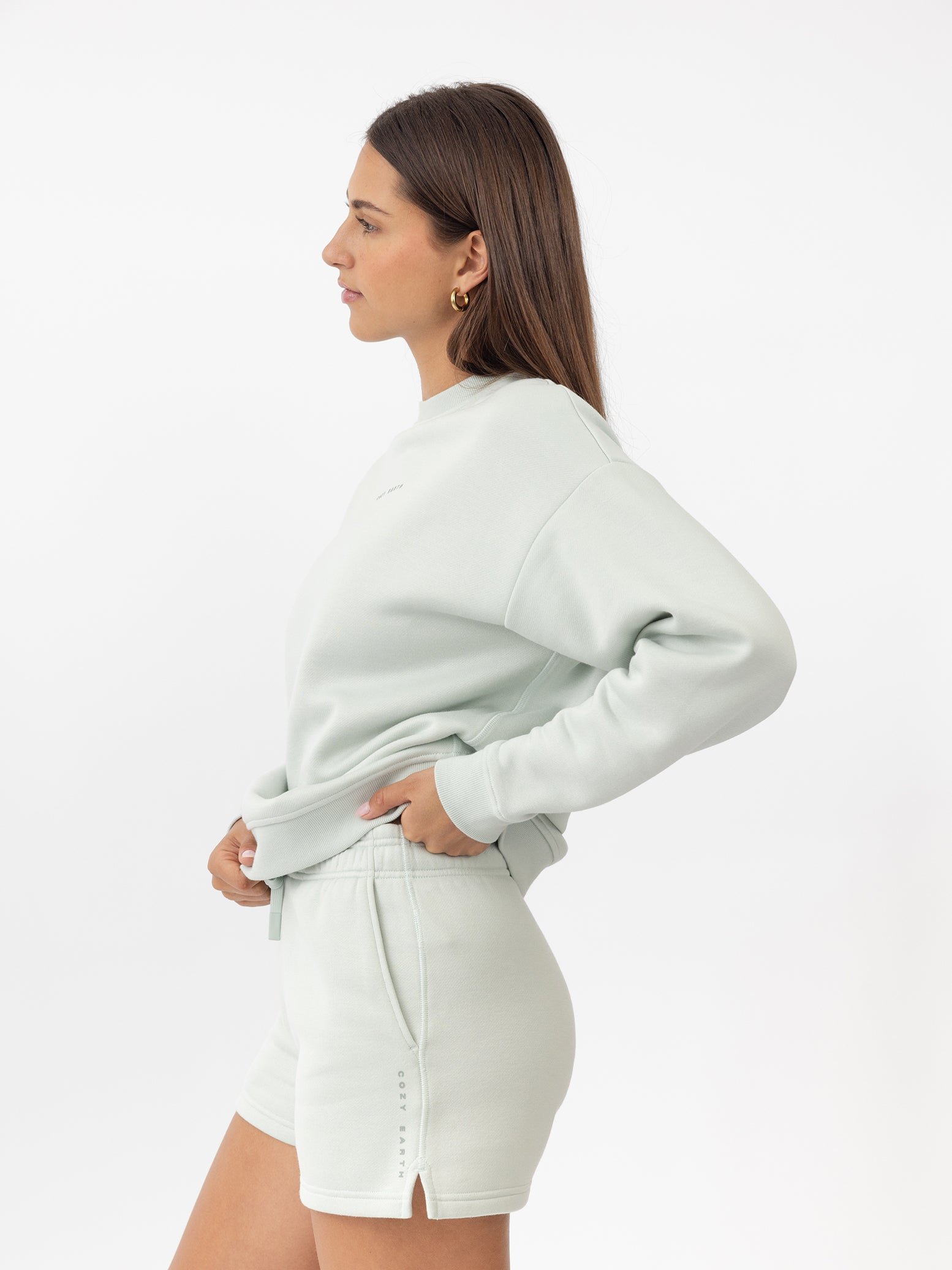 Arctic CityScape Pullover Crew. The Pullover is being worn by a female model. Accompanying city scape clothing is being worn to complete the look of the outfit. The photo was taken with a white background. 