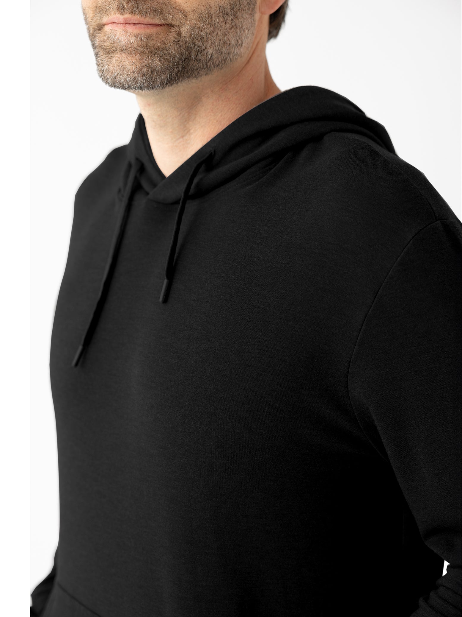 Close up of man wearing black hoodie with white background 