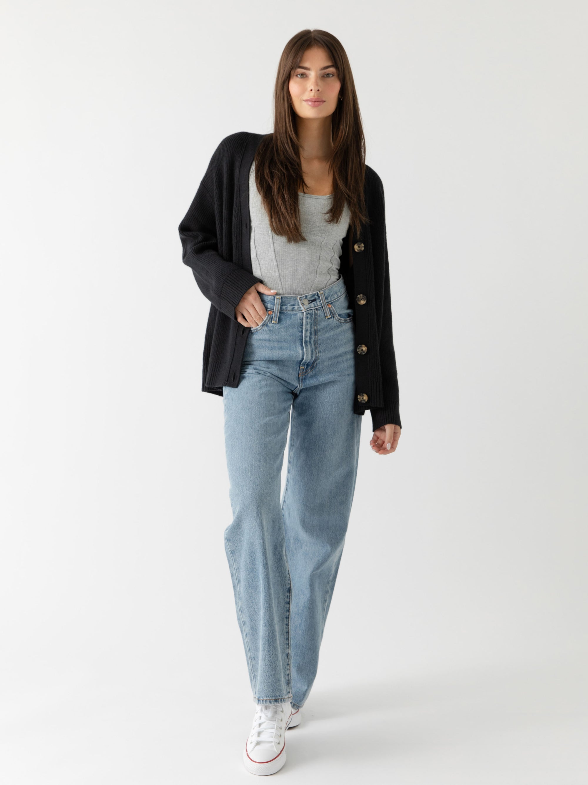 A woman wearing Cozy Earth Classic Cardigan in Black stands in front of a white background 