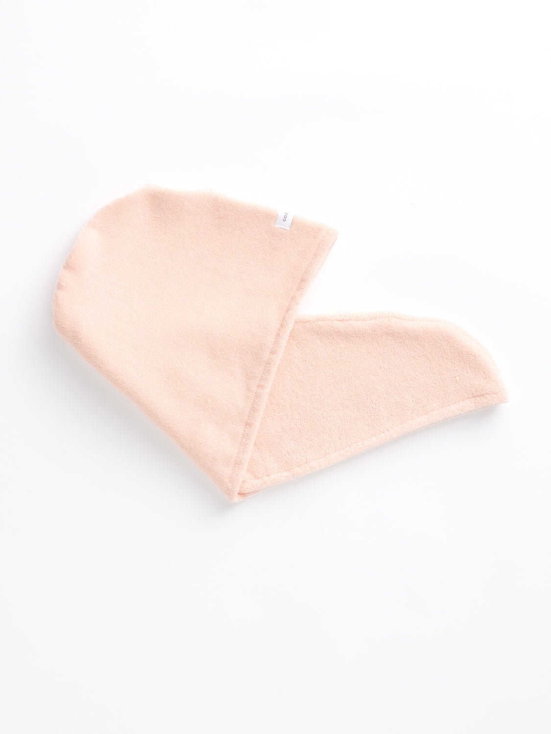 A Cozy Earth Hair Towel rests folded on a white background. 