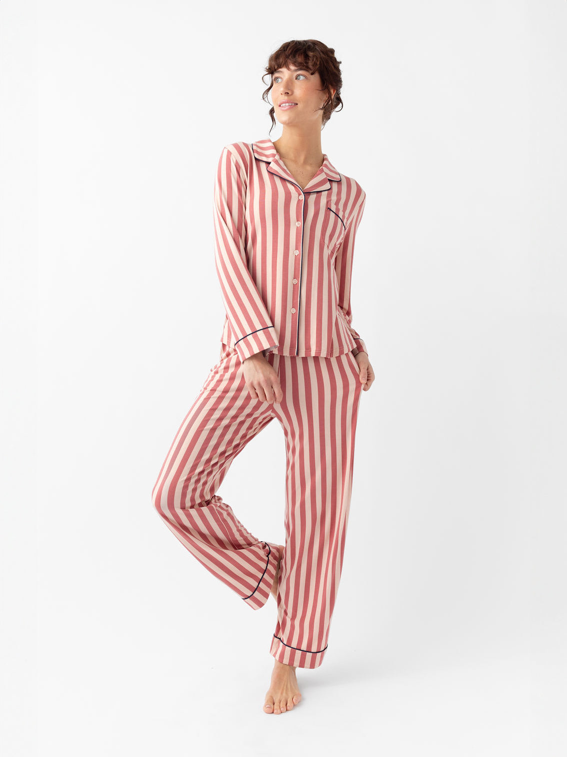 Woman wearing blush stripe pajama set with white background 