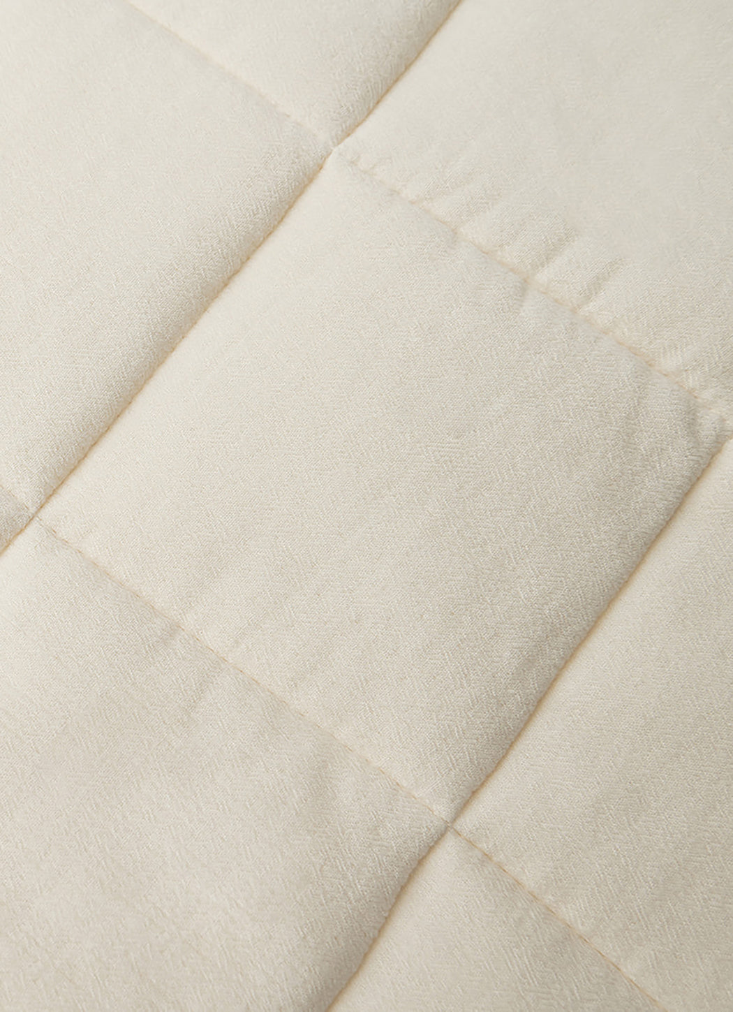 Close up of Buttermilk Aire Bamboo Box Quilt Euro Sham. The sham is resting on a bed in a bedroom