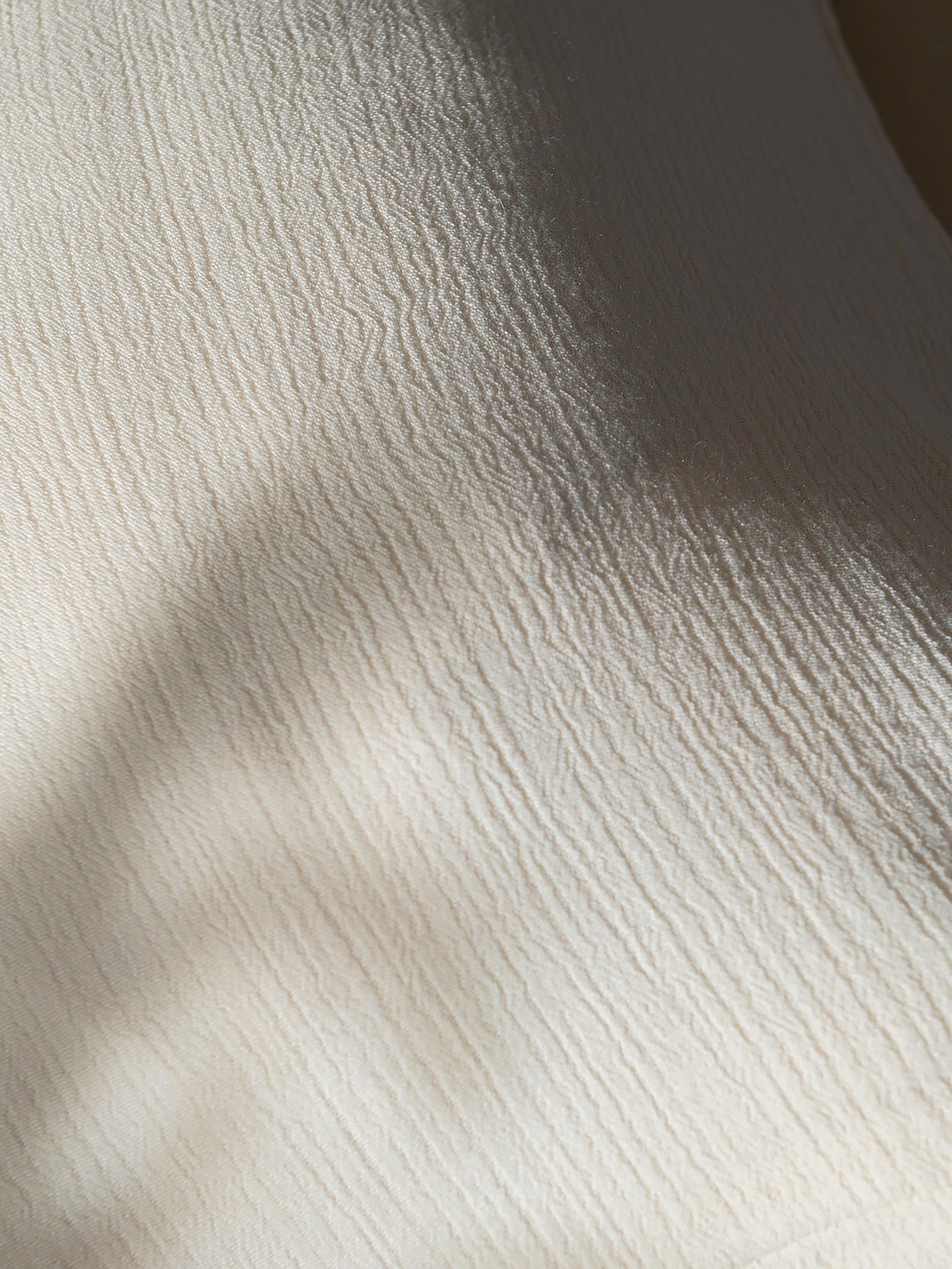 Close up of Buttermilk Aire Bamboo Sham. The sham is photographed close up resting on a bed