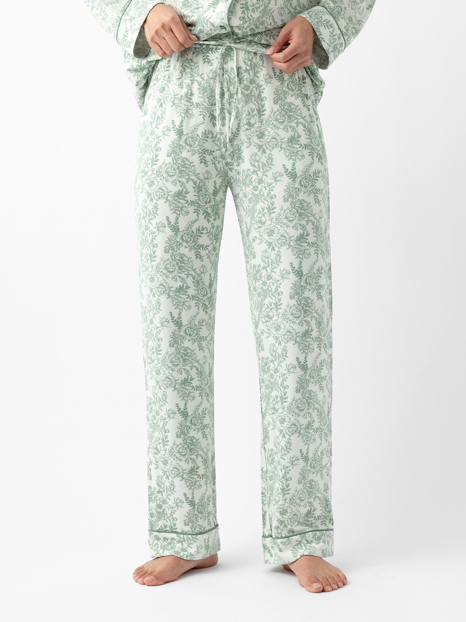 Woman in celadon toile pajama pants with white background 
