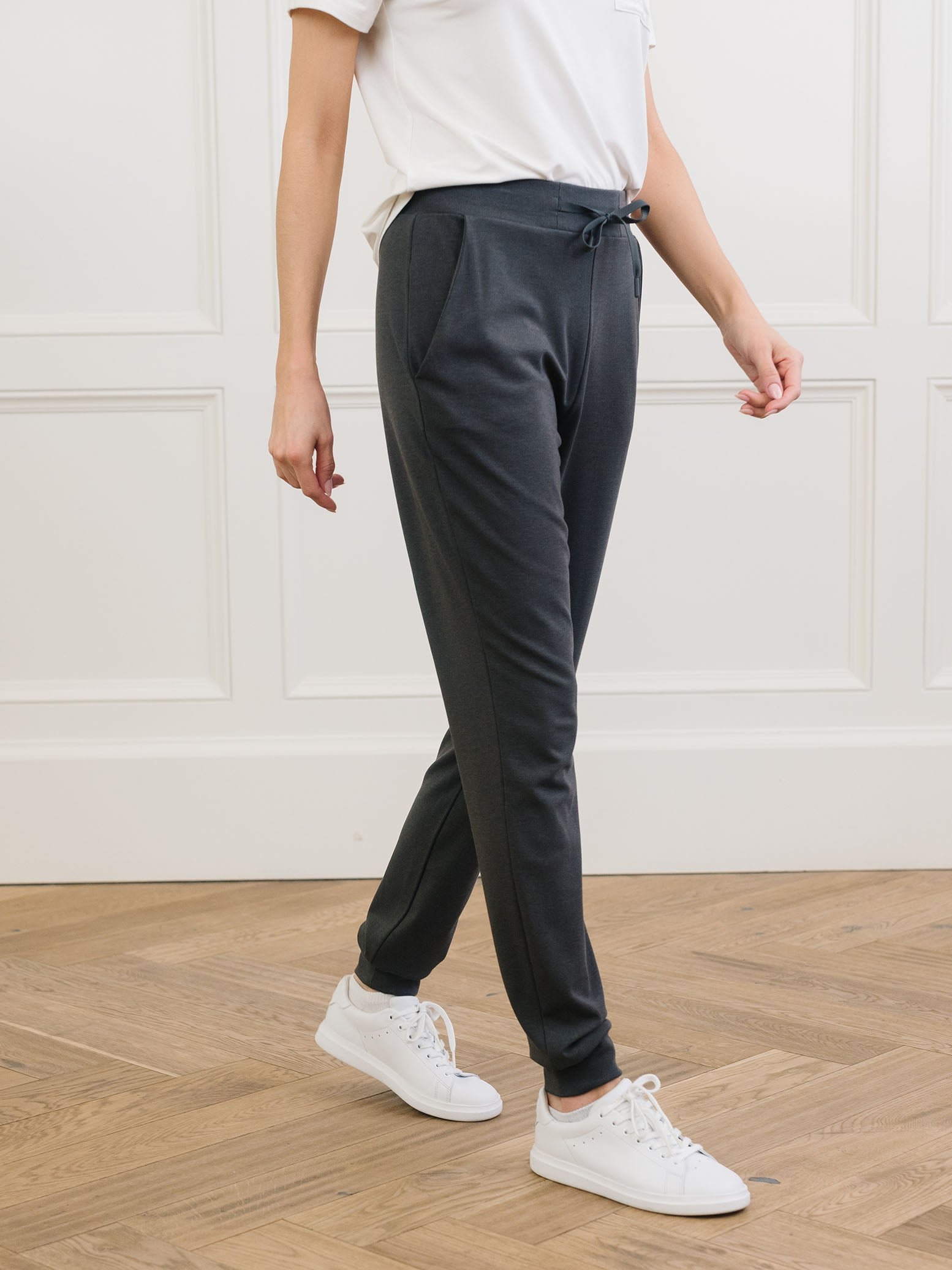Charcoal Bamboo Jogger Set modeled by a woman. The photo was taken in a high contrast setting, showing off the colors and lines of the pajamas. 