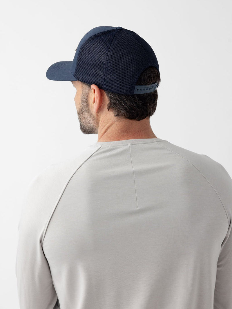 Back and side view of man wearing navy diamond mesh trucker hat