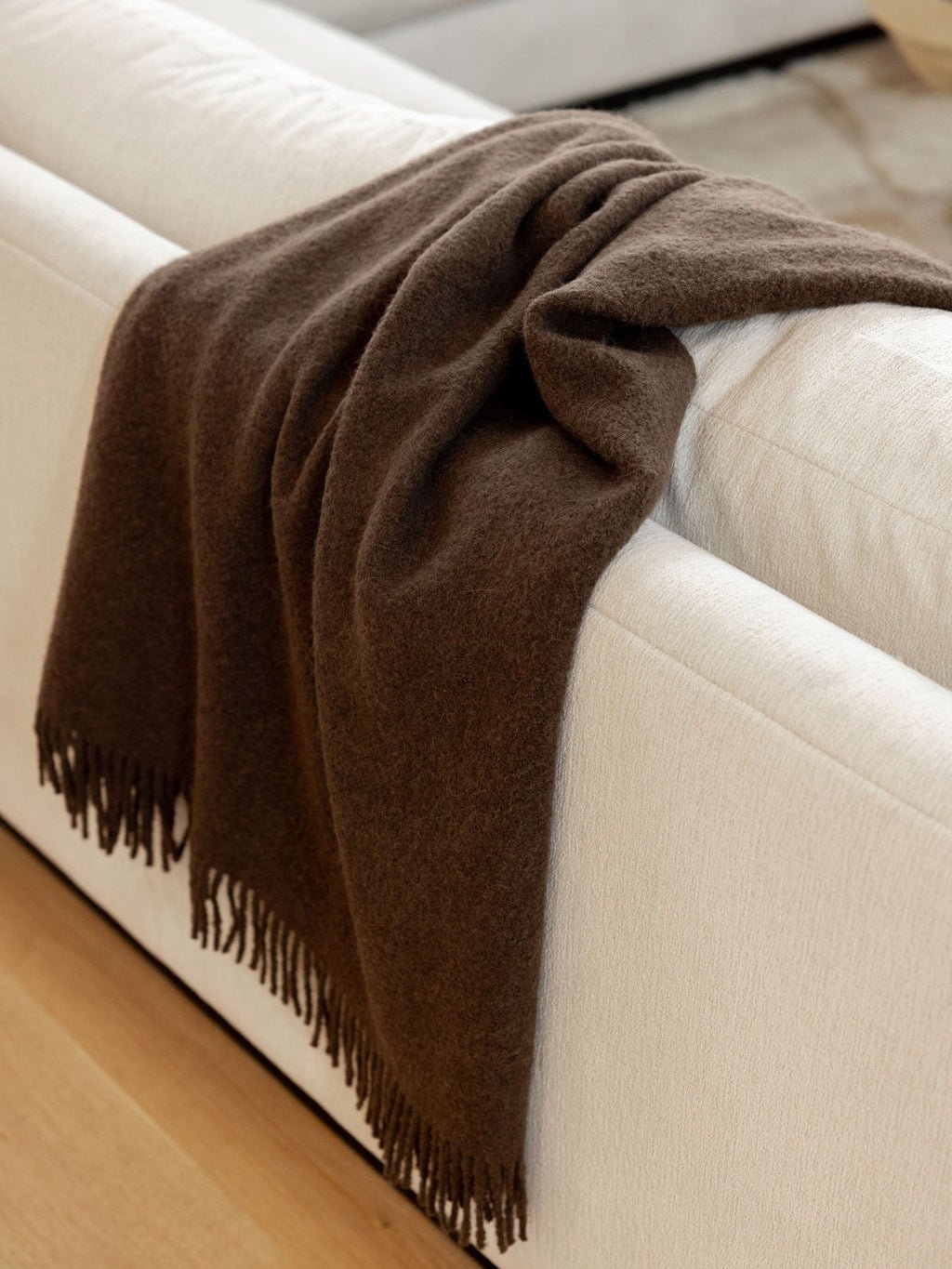 Coffee boucle throw draped over couch 