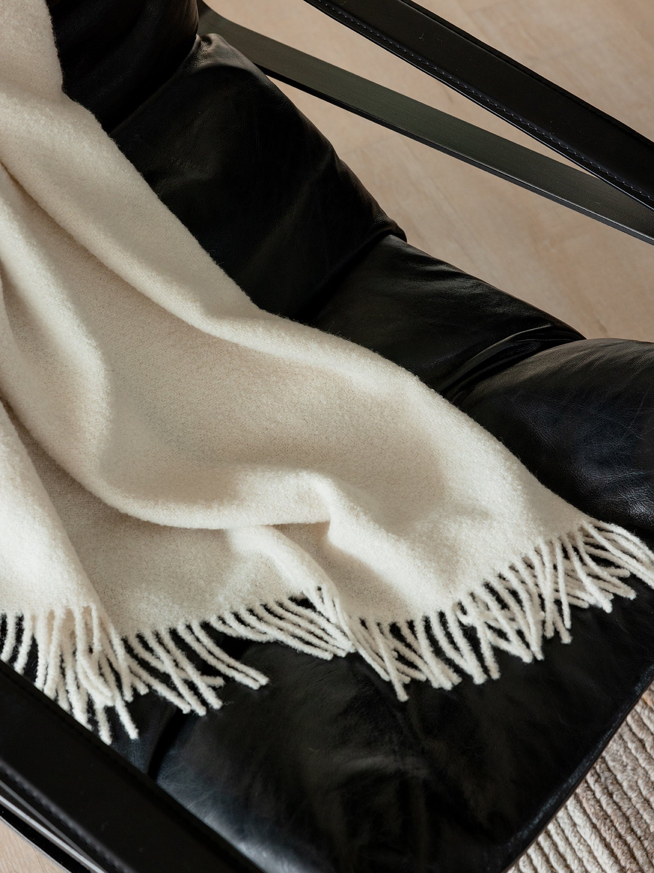Close up of creme boucle throw draped over an accent chair 